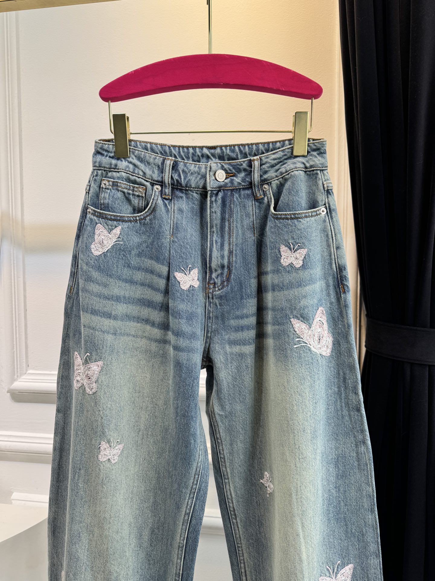 Ann Andel**蝴蝶刺绣弯刀牛仔裤融合轻奢设计与休闲丹宁风格的单品，以复古水洗丹宁为基底，搭配精致