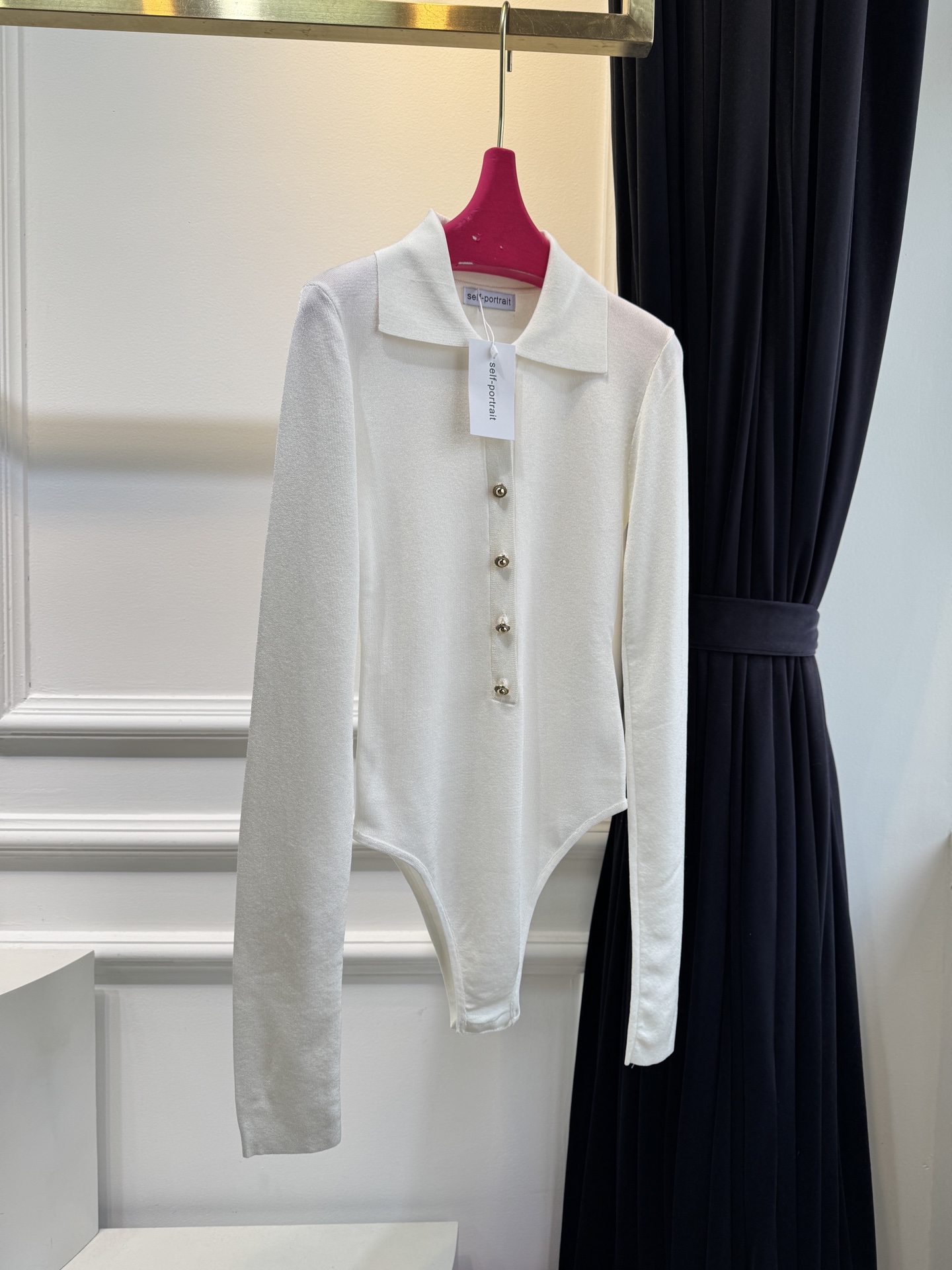 Self-Portrait针织连体衣采用翻领+金属纽扣的经典设计，修身剪裁贴合身形，连体式版型能避免穿搭