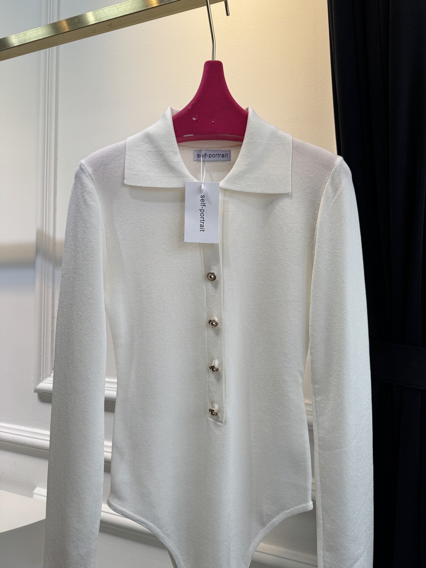 Self-Portrait针织连体衣采用翻领+金属纽扣的经典设计，修身剪裁贴合身形，连体式版型能避免穿搭