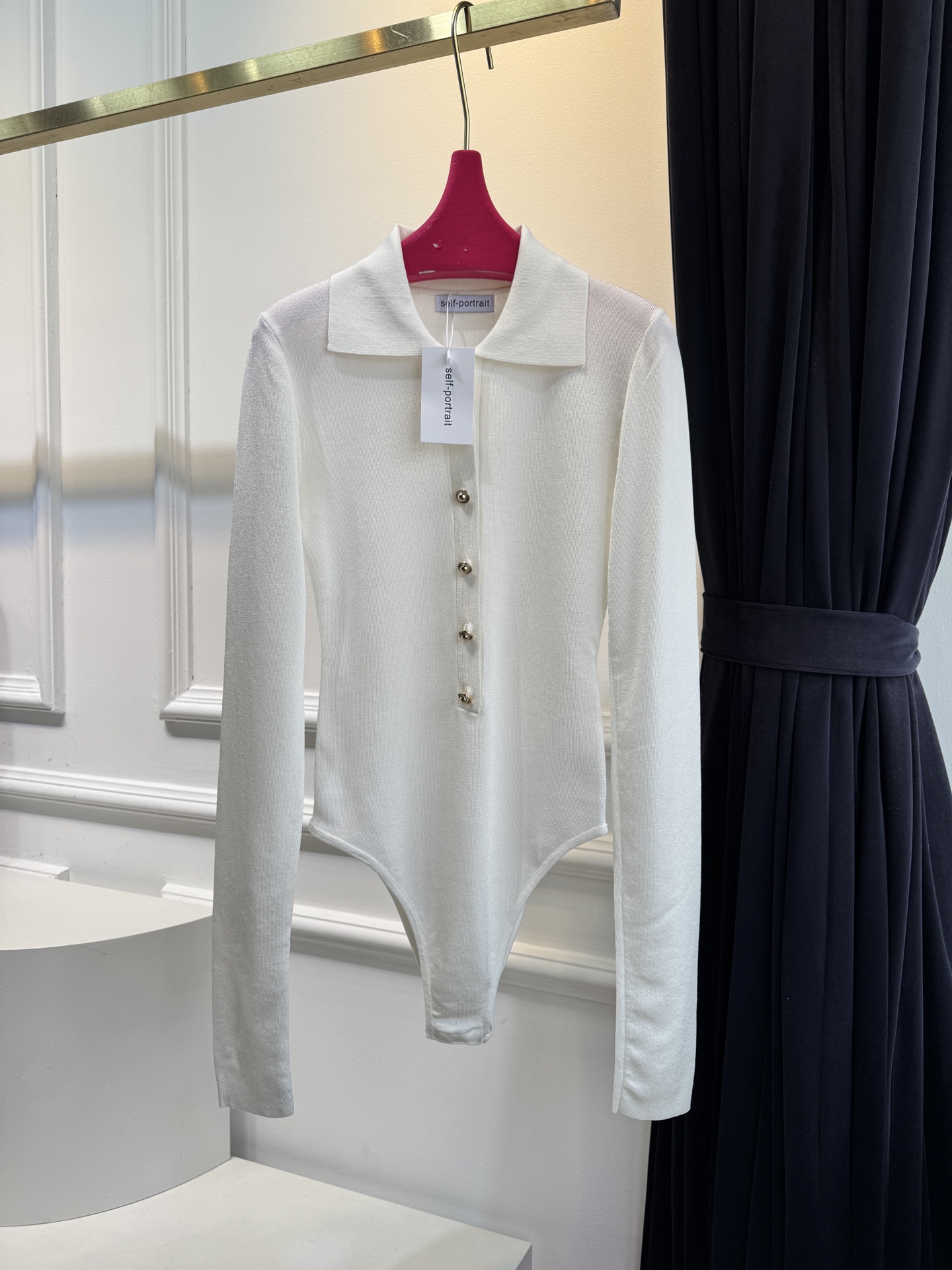 Self-Portrait针织连体衣采用翻领+金属纽扣的经典设计，修身剪裁贴合身形，连体式版型能避免穿搭