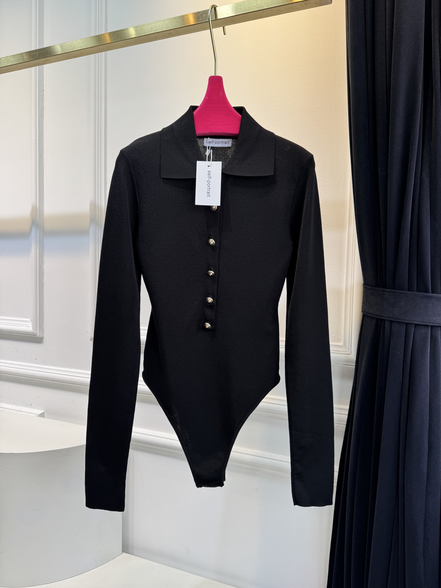 Self-Portrait针织连体衣采用翻领+金属纽扣的经典设计，修身剪裁贴合身形，连体式版型能避免穿搭