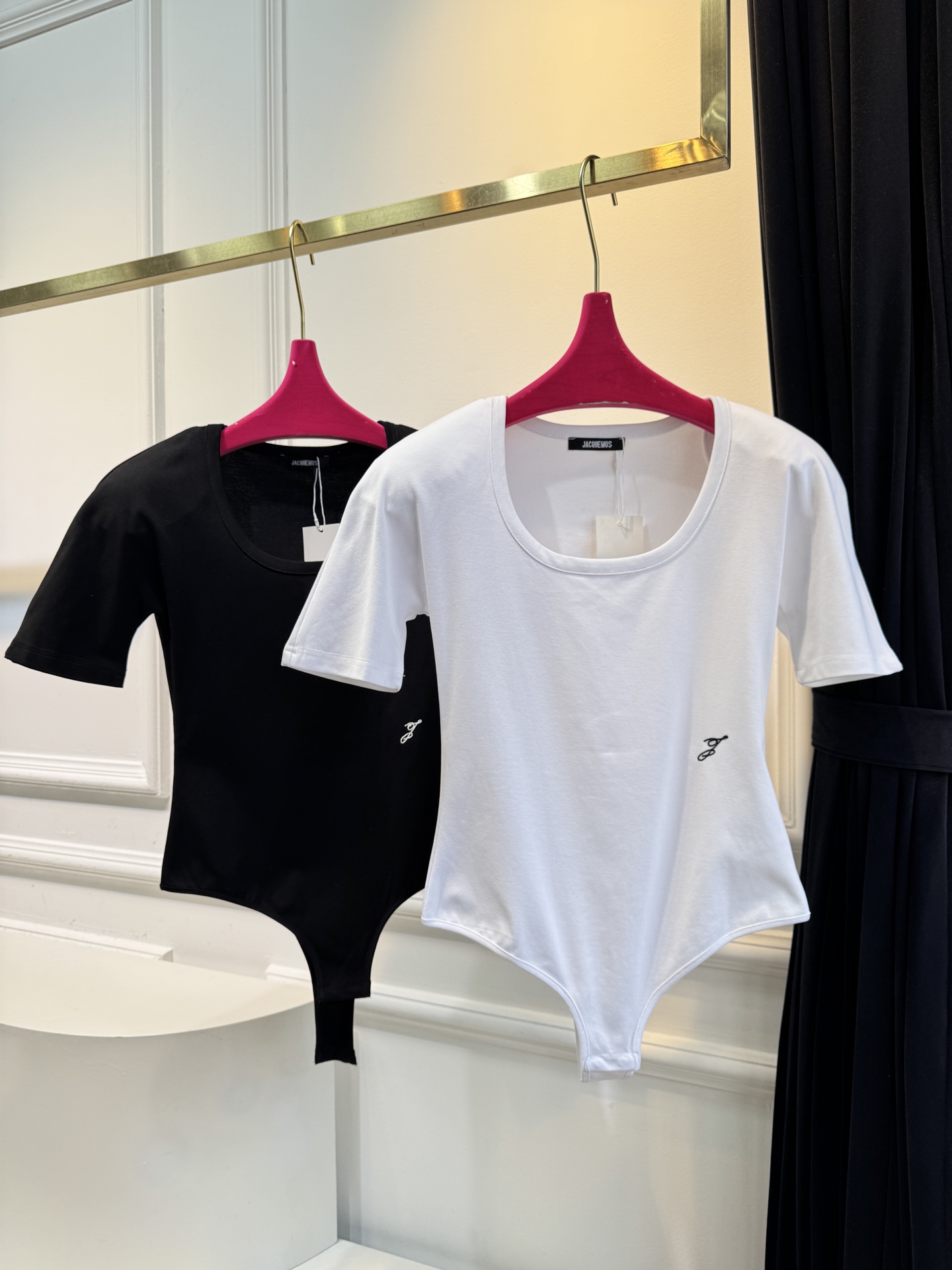 JACQUEMUS垫肩连体衣采用连体式的三角哈衣版型，搭配大U领与短袖设计，修身的剪裁能贴合身形，勾勒出