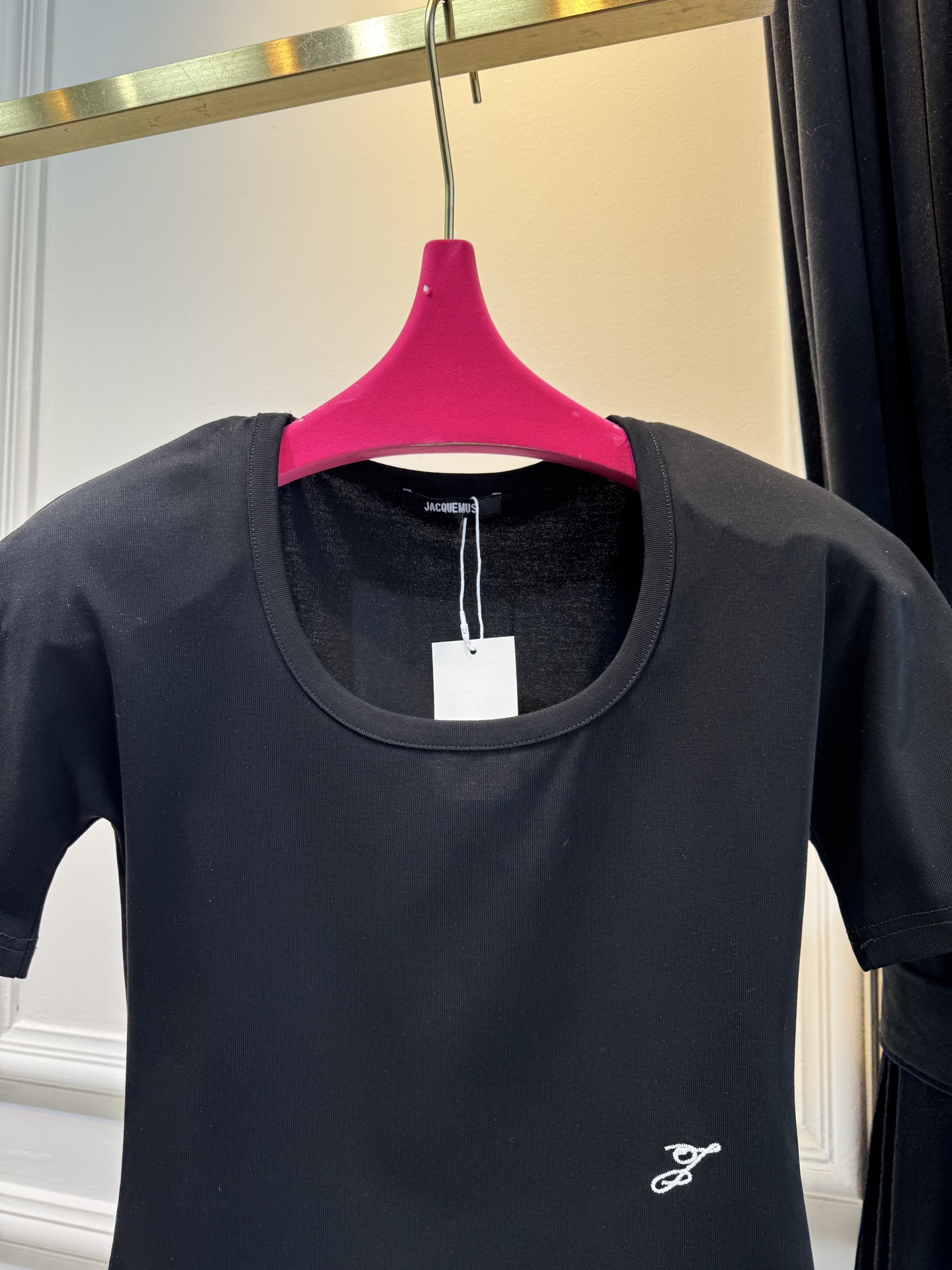 JACQUEMUS垫肩连体衣采用连体式的三角哈衣版型，搭配大U领与短袖设计，修身的剪裁能贴合身形，勾勒出