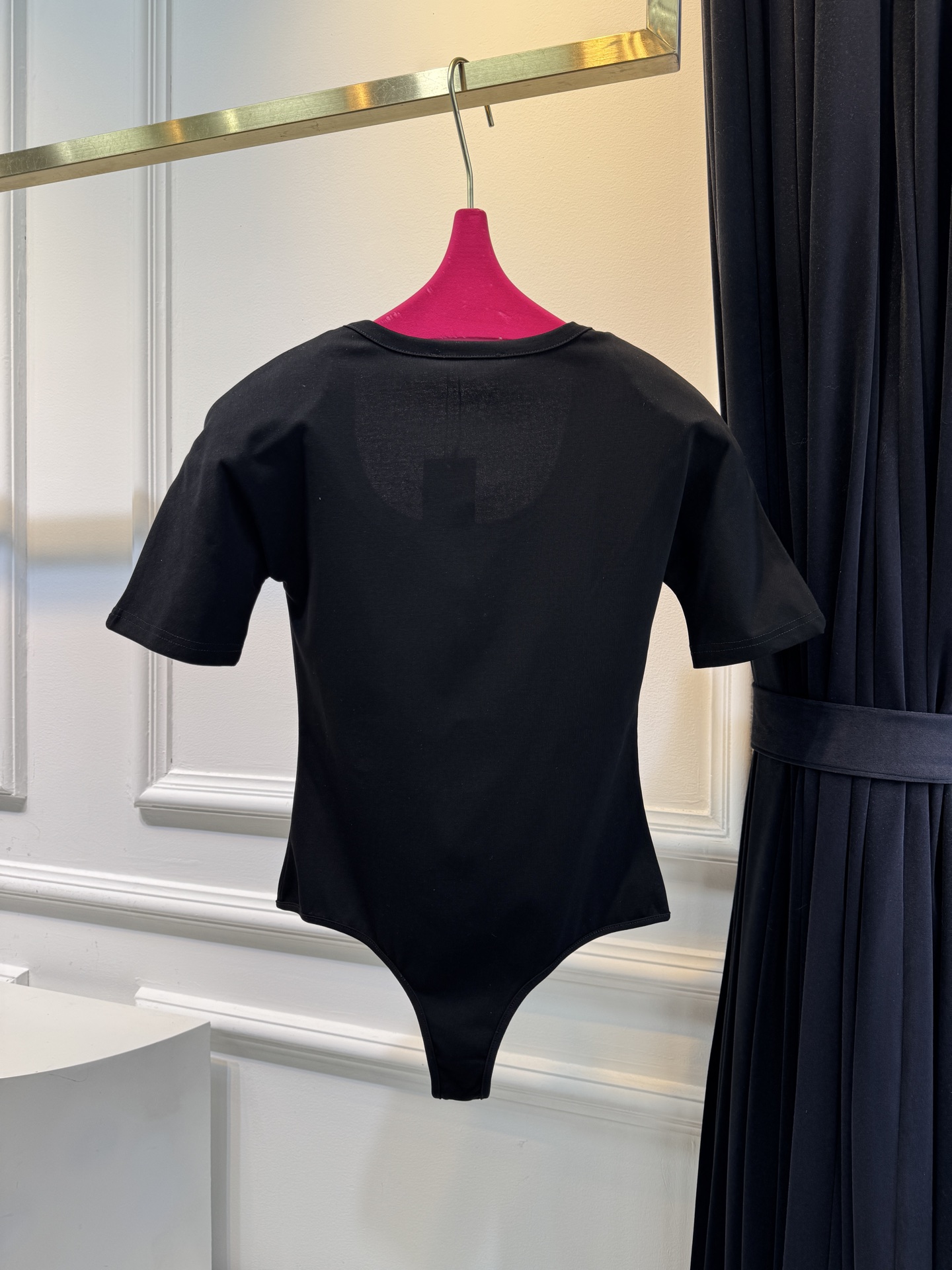 JACQUEMUS垫肩连体衣采用连体式的三角哈衣版型，搭配大U领与短袖设计，修身的剪裁能贴合身形，勾勒出