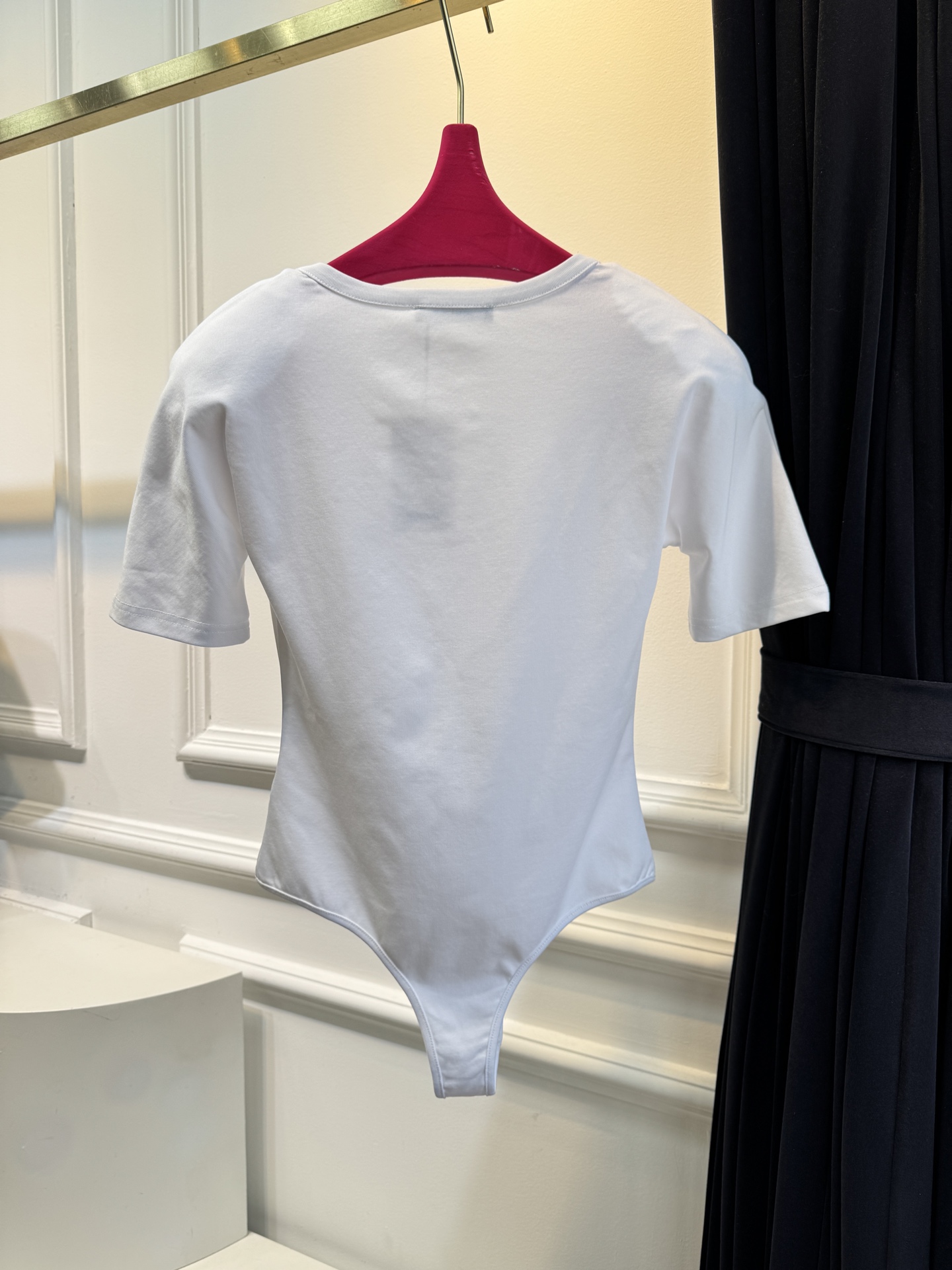 JACQUEMUS垫肩连体衣采用连体式的三角哈衣版型，搭配大U领与短袖设计，修身的剪裁能贴合身形，勾勒出