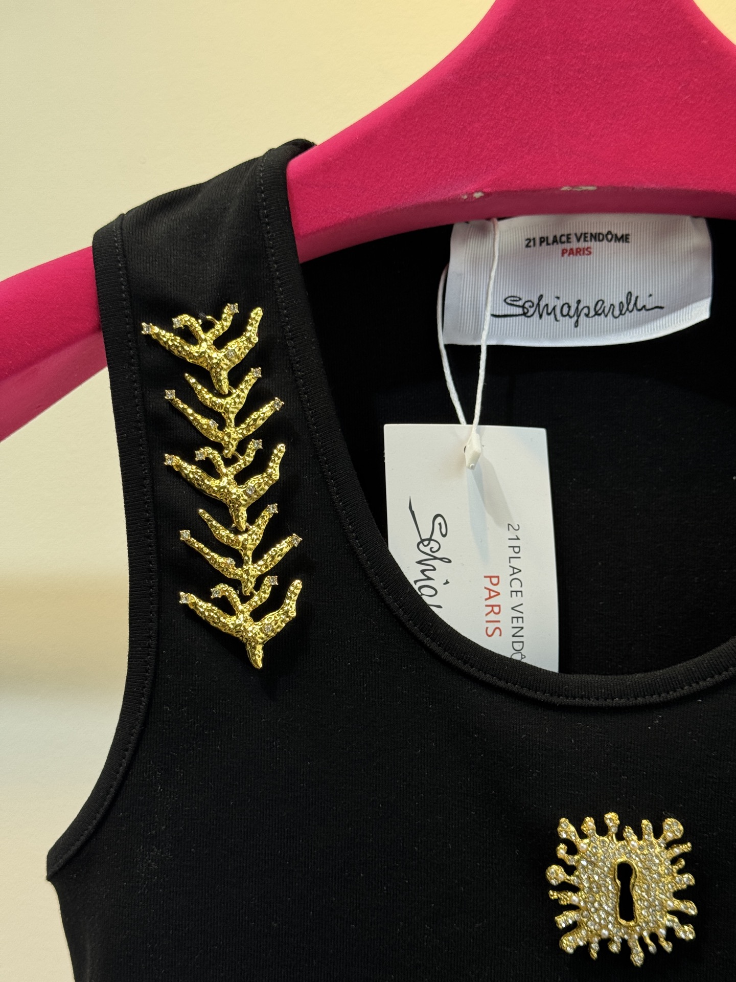 schiaparelli 麦穗金属背心1领口两侧有金色麦穗状钉珠装饰，胸口处搭配太阳花造型的金色金属装饰