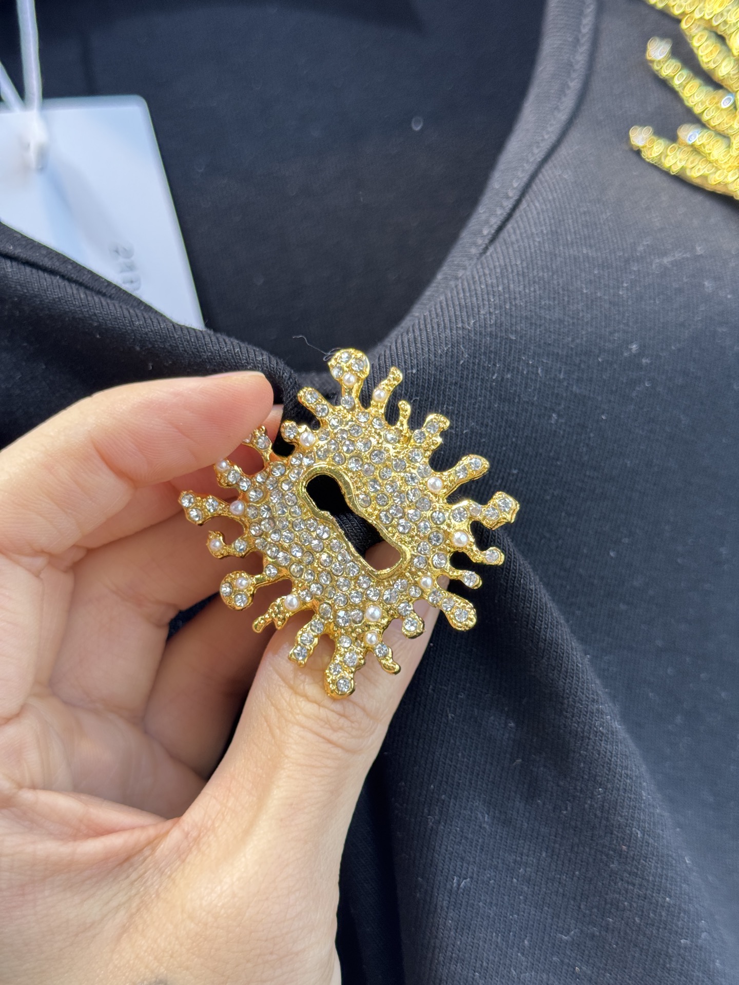 schiaparelli 麦穗金属背心1领口两侧有金色麦穗状钉珠装饰，胸口处搭配太阳花造型的金色金属装饰