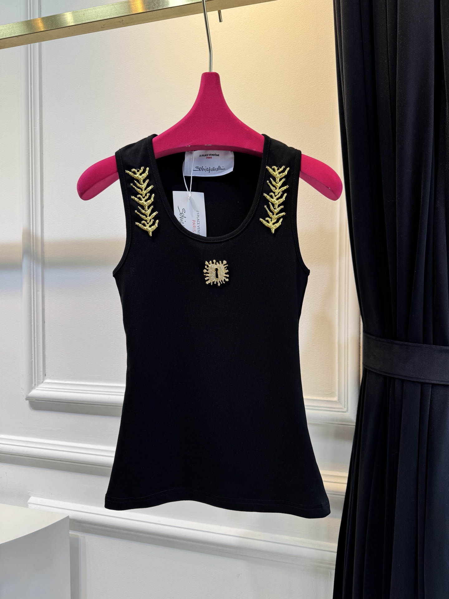 schiaparelli 麦穗金属背心1领口两侧有金色麦穗状钉珠装饰，胸口处搭配太阳花造型的金色金属装饰