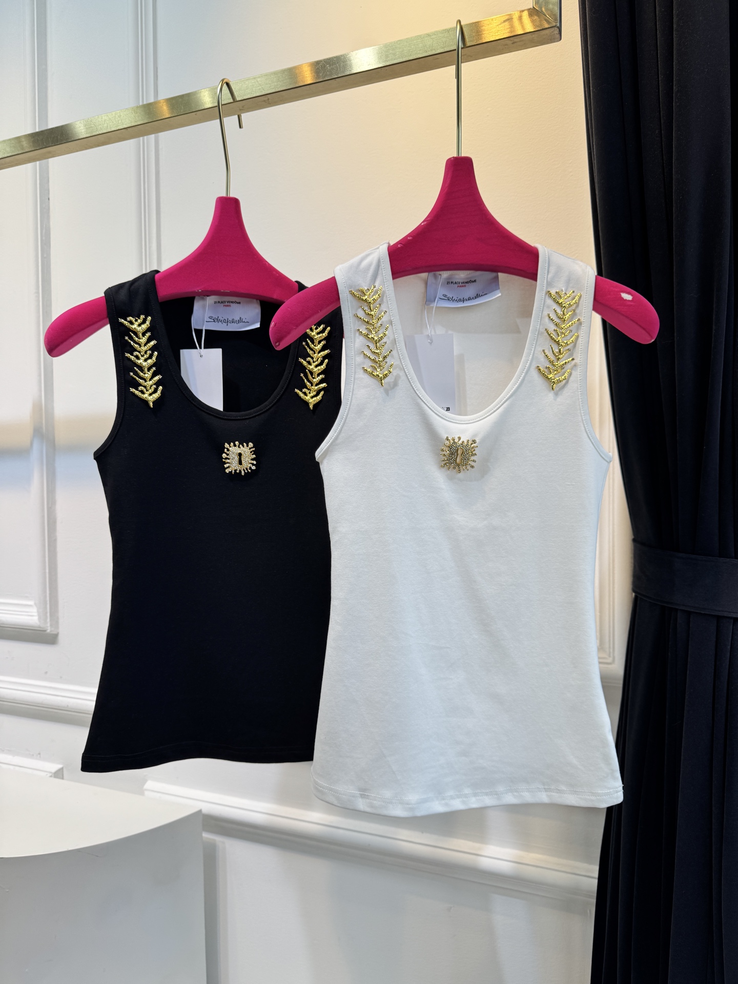 schiaparelli 麦穗金属背心1领口两侧有金色麦穗状钉珠装饰，胸口处搭配太阳花造型的金色金属装饰