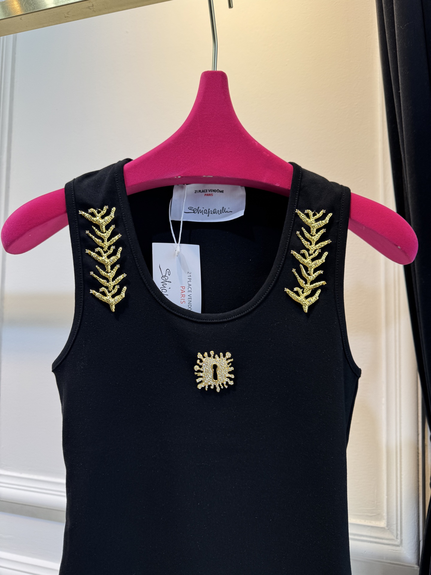 schiaparelli 麦穗金属背心1领口两侧有金色麦穗状钉珠装饰，胸口处搭配太阳花造型的金色金属装饰