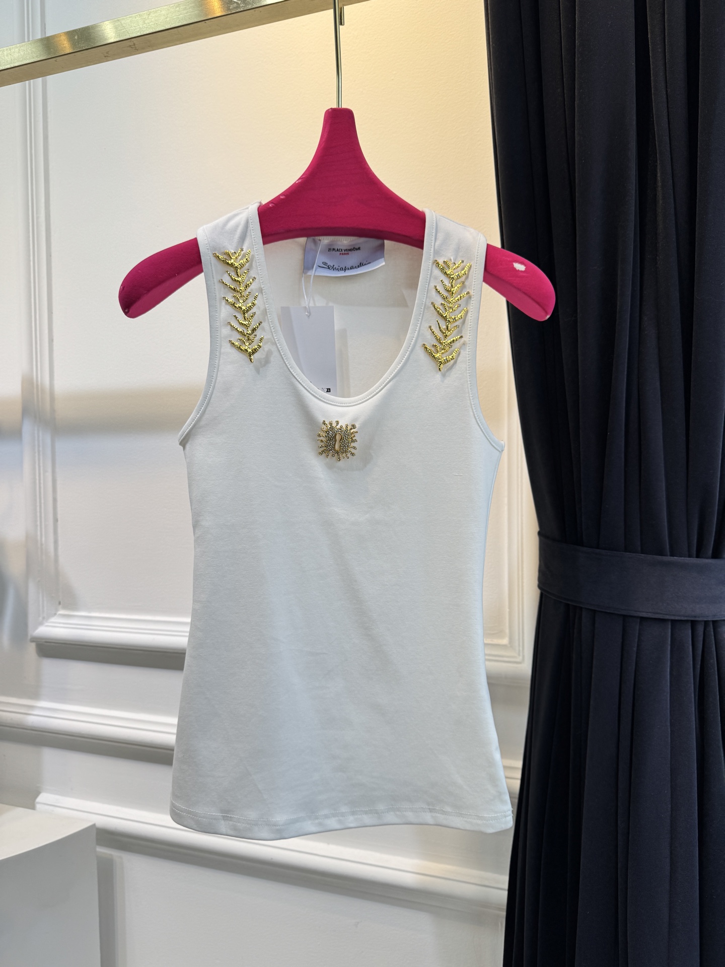 schiaparelli 麦穗金属背心1领口两侧有金色麦穗状钉珠装饰，胸口处搭配太阳花造型的金色金属装饰