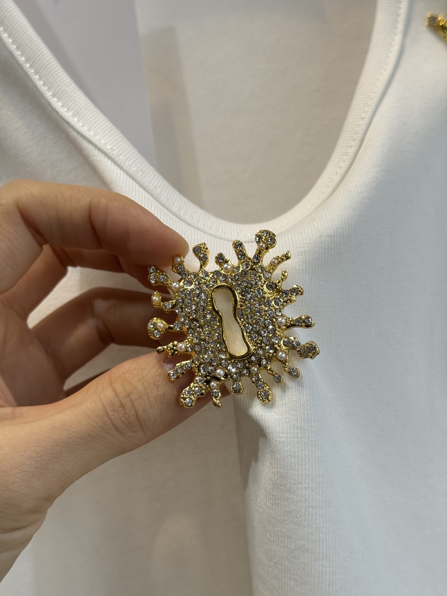 schiaparelli 麦穗金属背心1领口两侧有金色麦穗状钉珠装饰，胸口处搭配太阳花造型的金色金属装饰