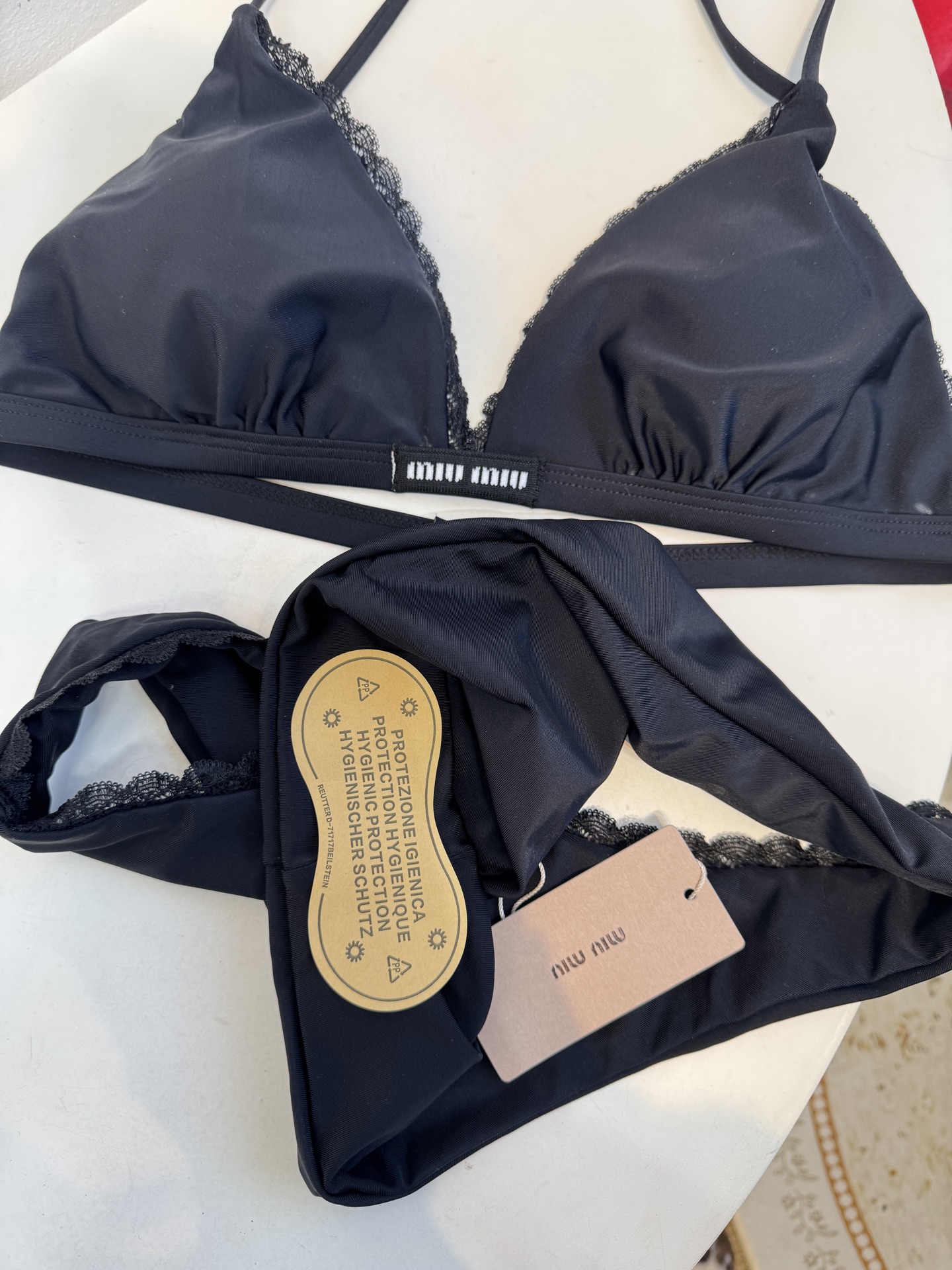 Miu 蕾丝边比基尼泳衣/内衣三角杯挂脖式上装+高切半包臀下装，上装后片配有排扣设计可调节围度，下装侧边