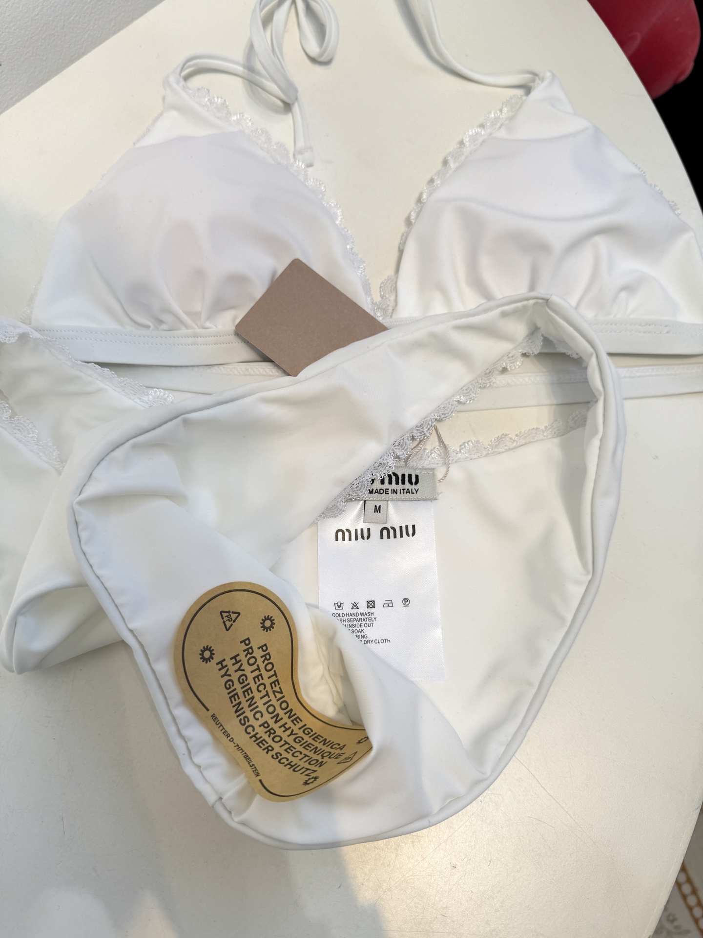 Miu 蕾丝边比基尼泳衣/内衣三角杯挂脖式上装+高切半包臀下装，上装后片配有排扣设计可调节围度，下装侧边