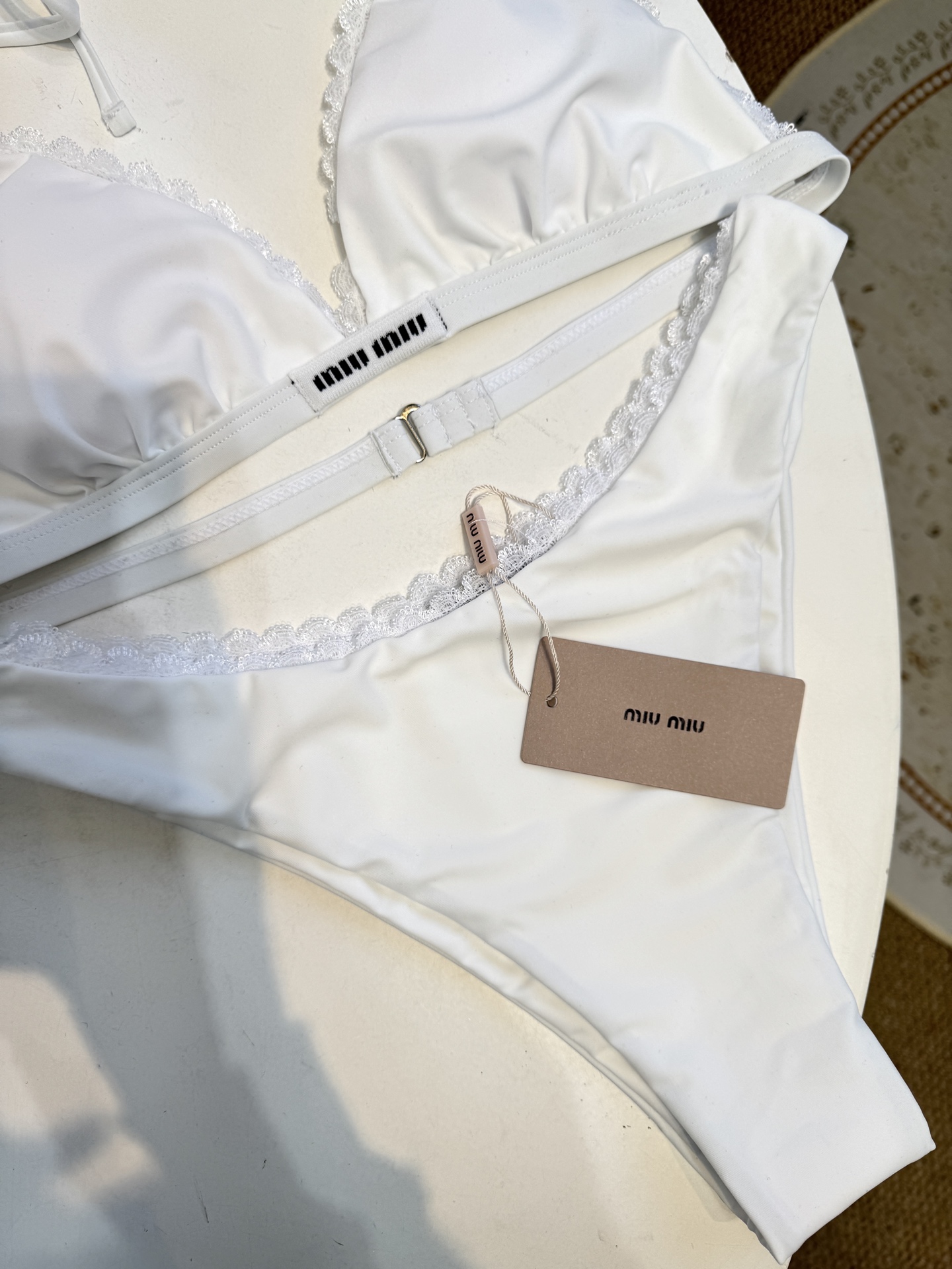 Miu 蕾丝边比基尼泳衣/内衣三角杯挂脖式上装+高切半包臀下装，上装后片配有排扣设计可调节围度，下装侧边