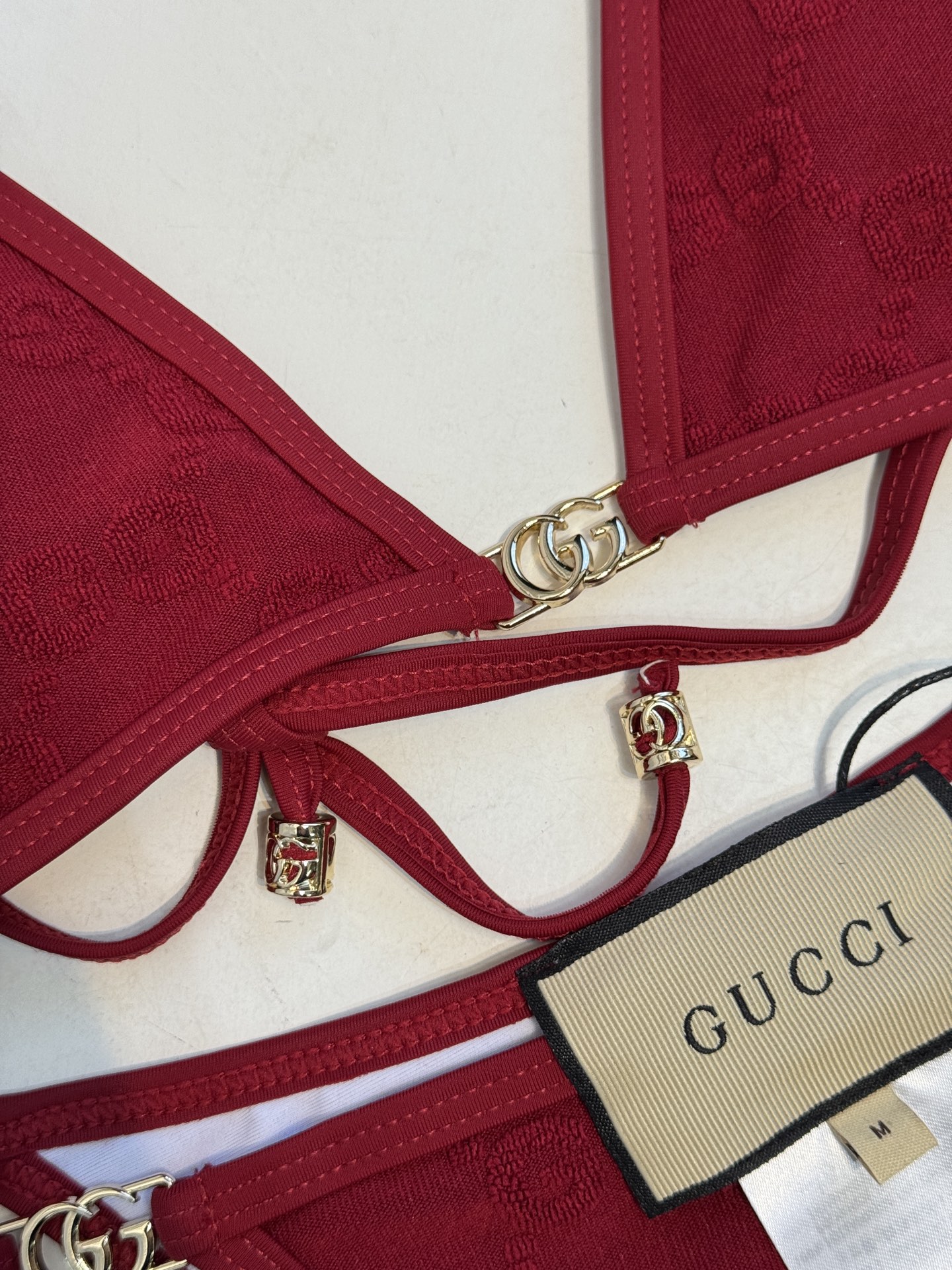 guc* 提花比基尼泳衣三角杯细肩带挂脖式上装+高切系带款下装，属于轻奢性感风格的分体泳衣，下装侧边的金