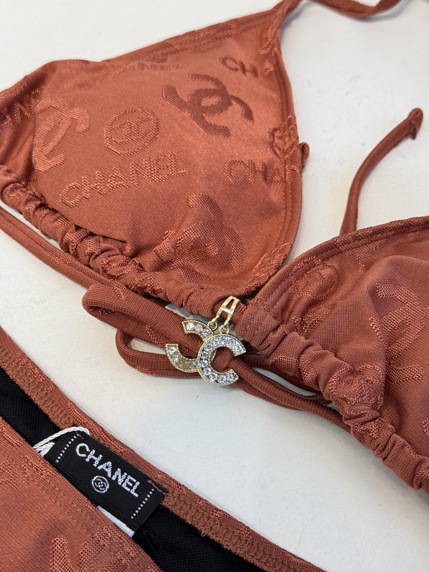 Chan* 提花比基尼泳衣经典三角杯挂脖式上装+高切半包臀下装，属于性感度假风的分体泳衣款式。面料带有香