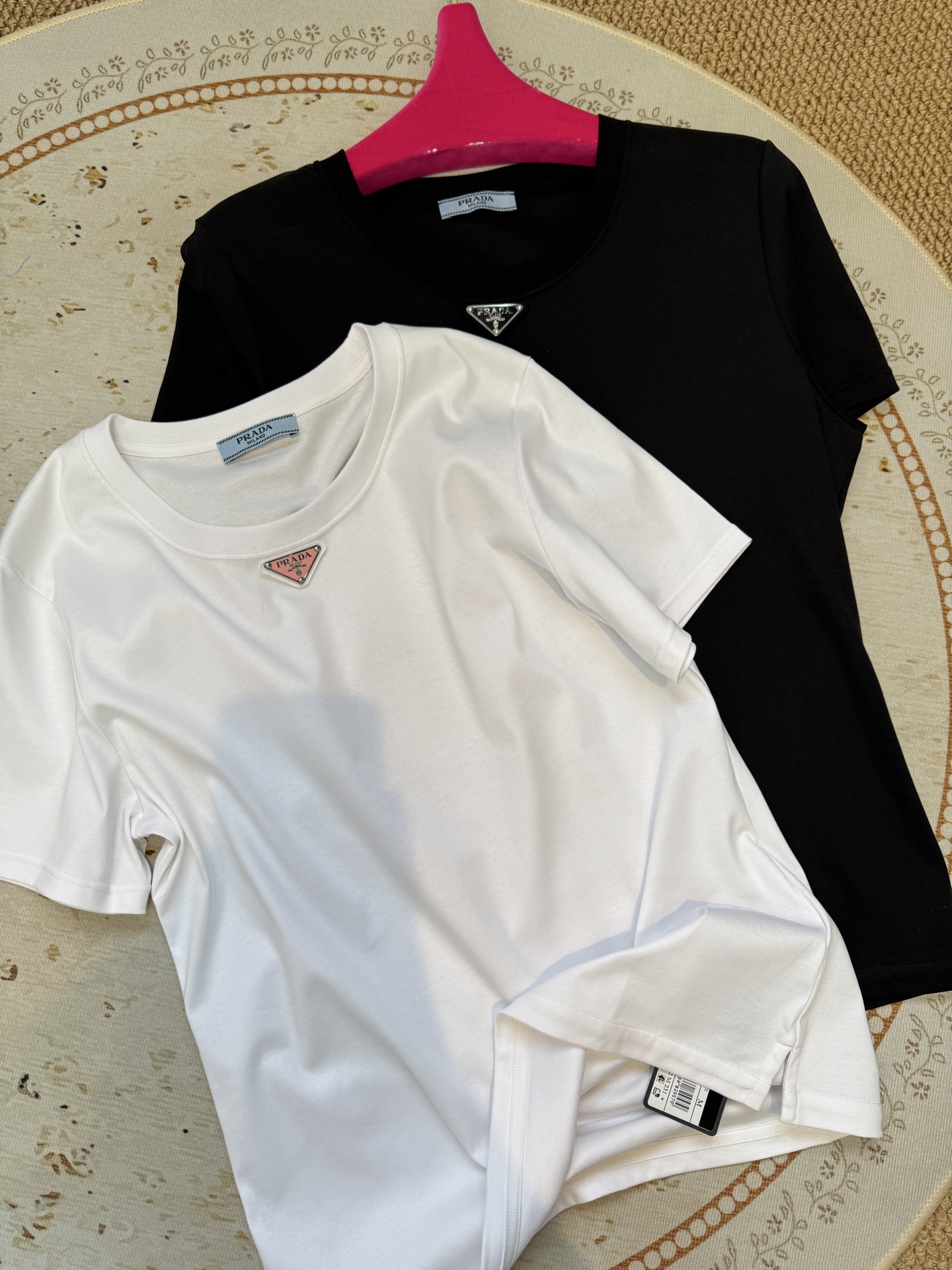 Prad*三角标圆领短袖T恤，胸前正下方的金属三角徽标是Prada的经典标识，采用品牌专属的金属材质与浮
