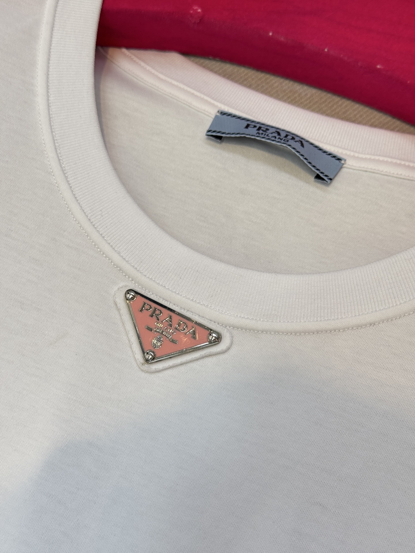 Prad*三角标圆领短袖T恤，胸前正下方的金属三角徽标是Prada的经典标识，采用品牌专属的金属材质与浮