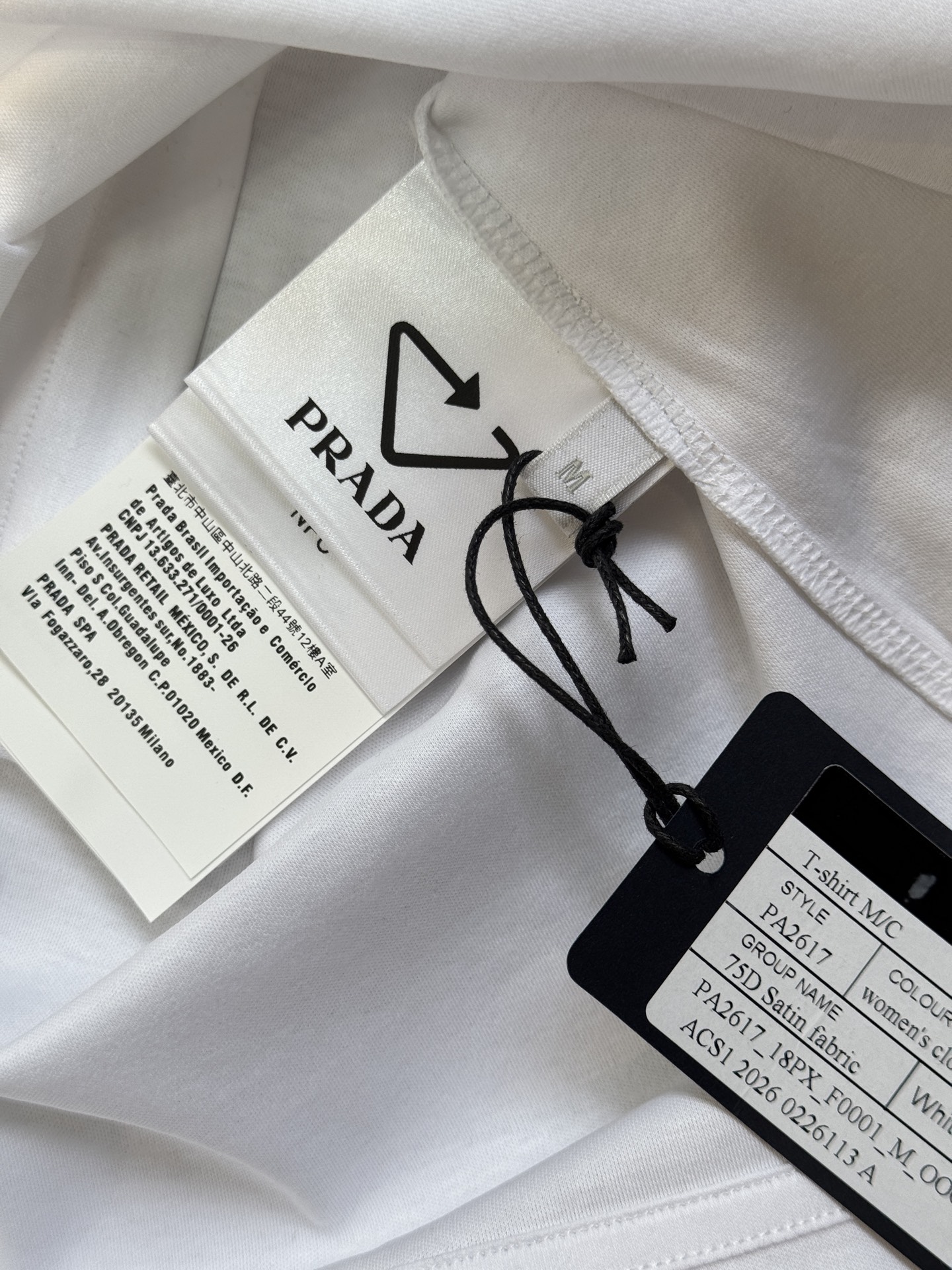 Prad*三角标圆领短袖T恤，胸前正下方的金属三角徽标是Prada的经典标识，采用品牌专属的金属材质与浮