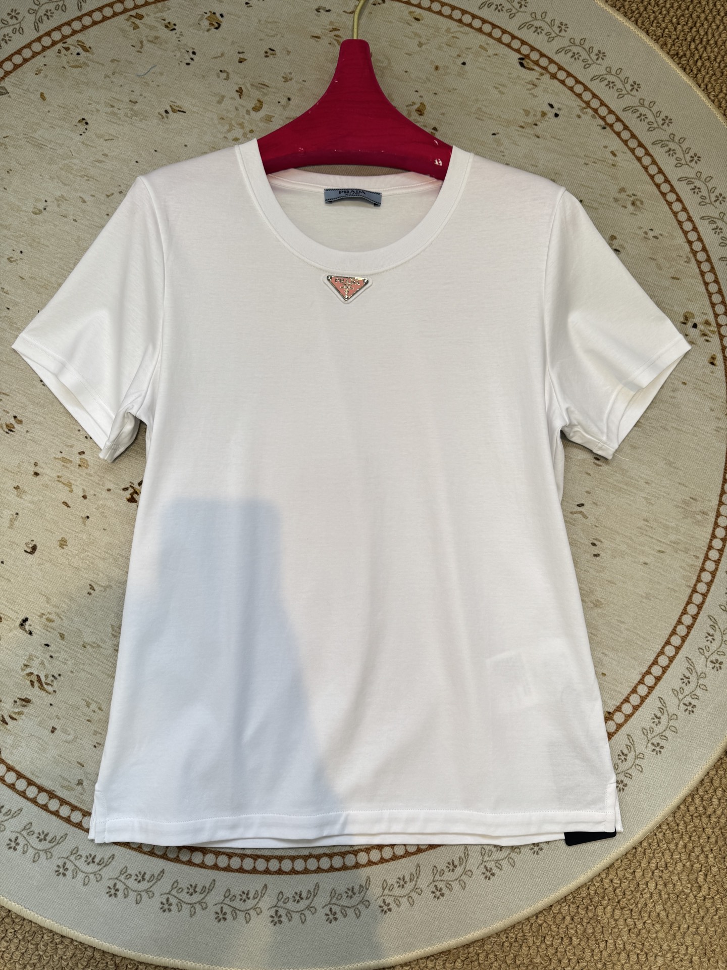 Prad*三角标圆领短袖T恤，胸前正下方的金属三角徽标是Prada的经典标识，采用品牌专属的金属材质与浮