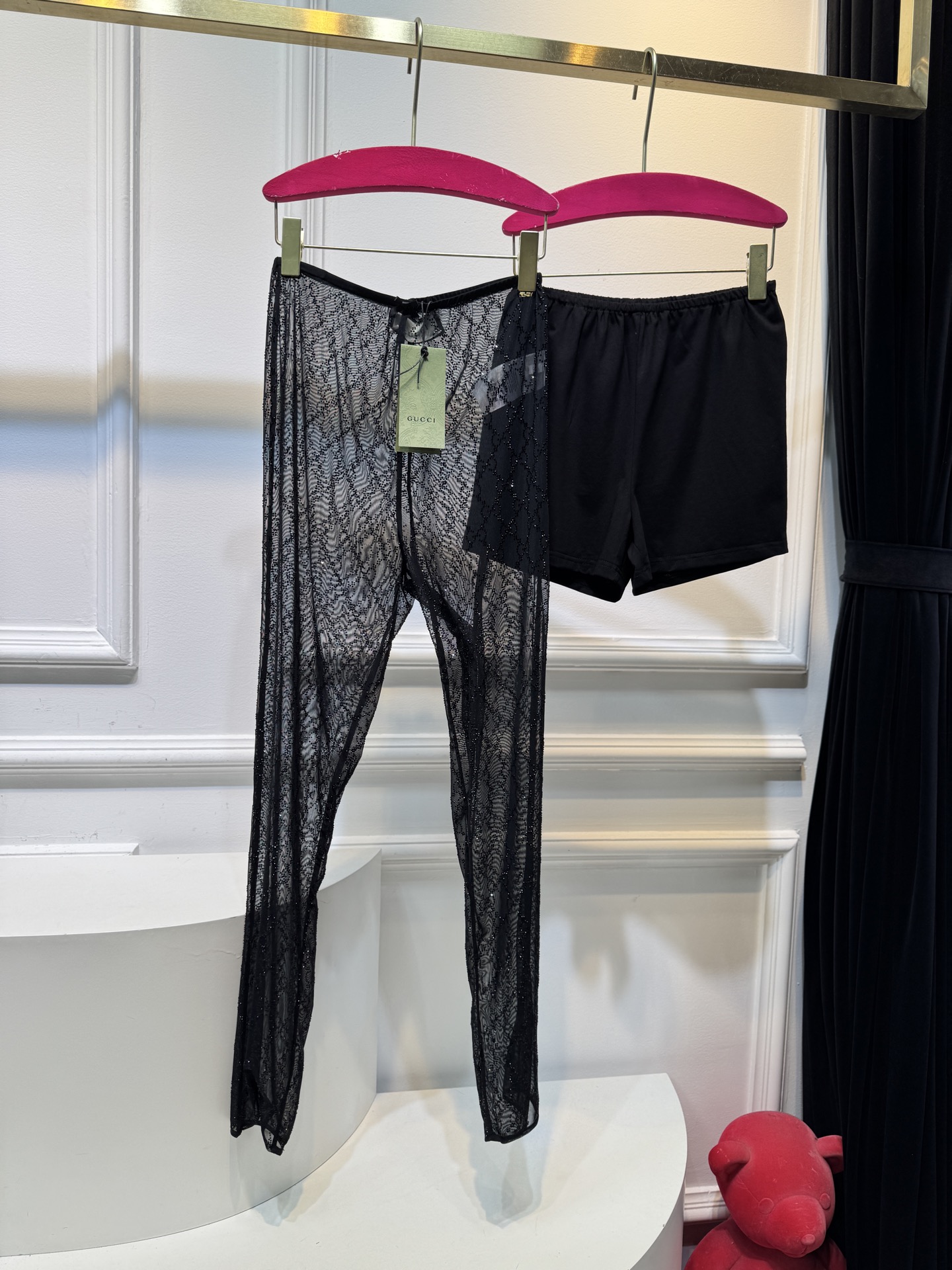 gucc* 饰GG仿水晶薄纱蕾丝紧身裤外层为深棕色蕾丝透视长裤，带有双G暗纹与烫钻点缀，裤脚处的双G烫钻