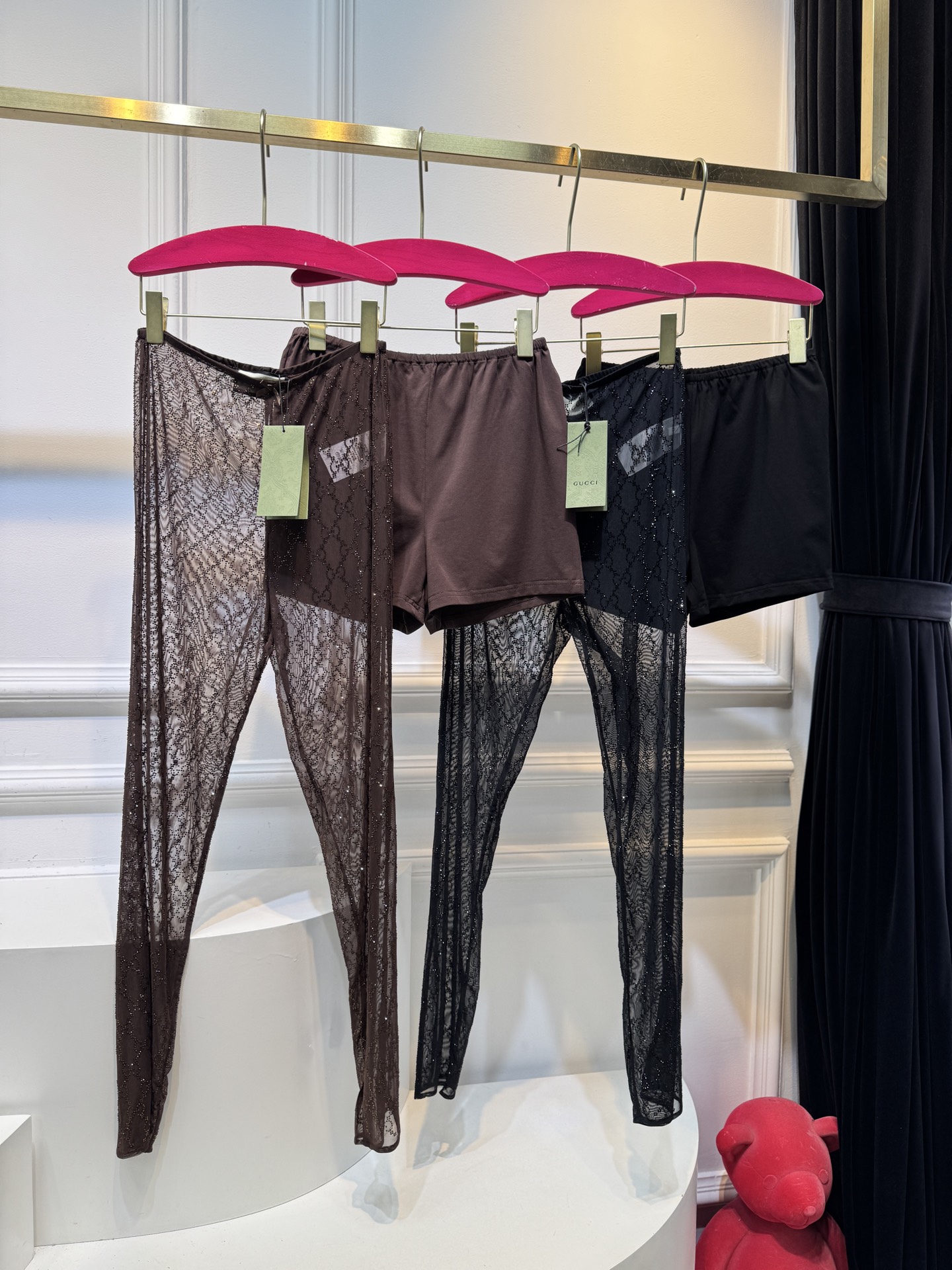 gucc* 饰GG仿水晶薄纱蕾丝紧身裤外层为深棕色蕾丝透视长裤，带有双G暗纹与烫钻点缀，裤脚处的双G烫钻