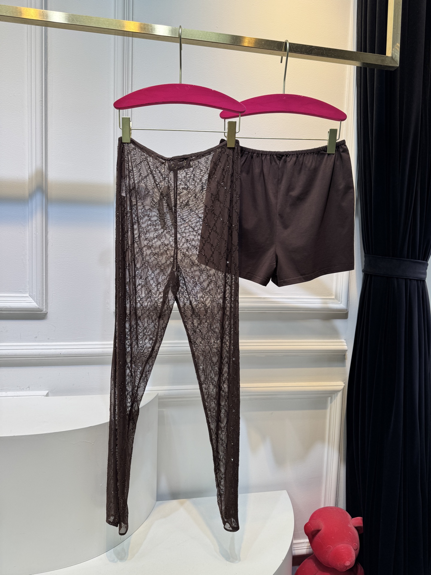 gucc* 饰GG仿水晶薄纱蕾丝紧身裤外层为深棕色蕾丝透视长裤，带有双G暗纹与烫钻点缀，裤脚处的双G烫钻