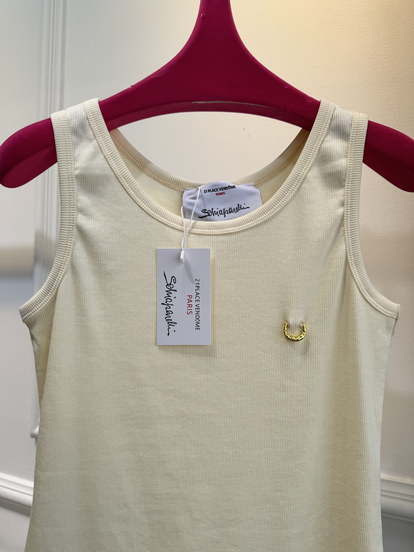 Schiaparelli（夏帕瑞丽）螺纹背心采用黑色罗纹针织面料，左胸处有标志性的金色月牙形金属装饰穿刺