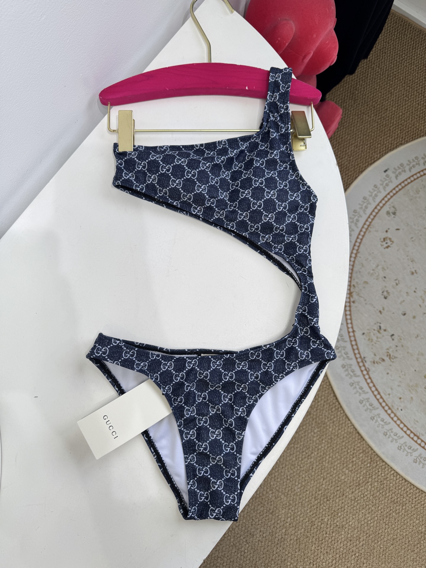 Gucci GG印花单肩镂空连体泳衣不对称美学：单肩吊带+腰部镂空的不对称剪裁，既修饰身形又极具辨识度，