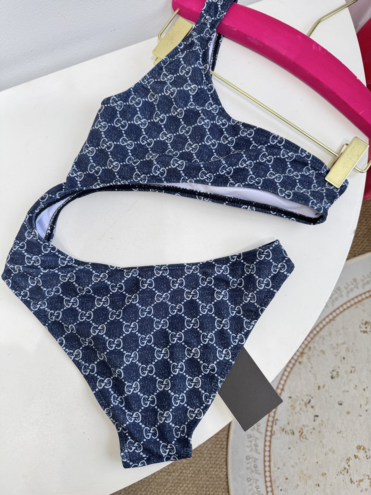 Gucci GG印花单肩镂空连体泳衣不对称美学：单肩吊带+腰部镂空的不对称剪裁，既修饰身形又极具辨识度，