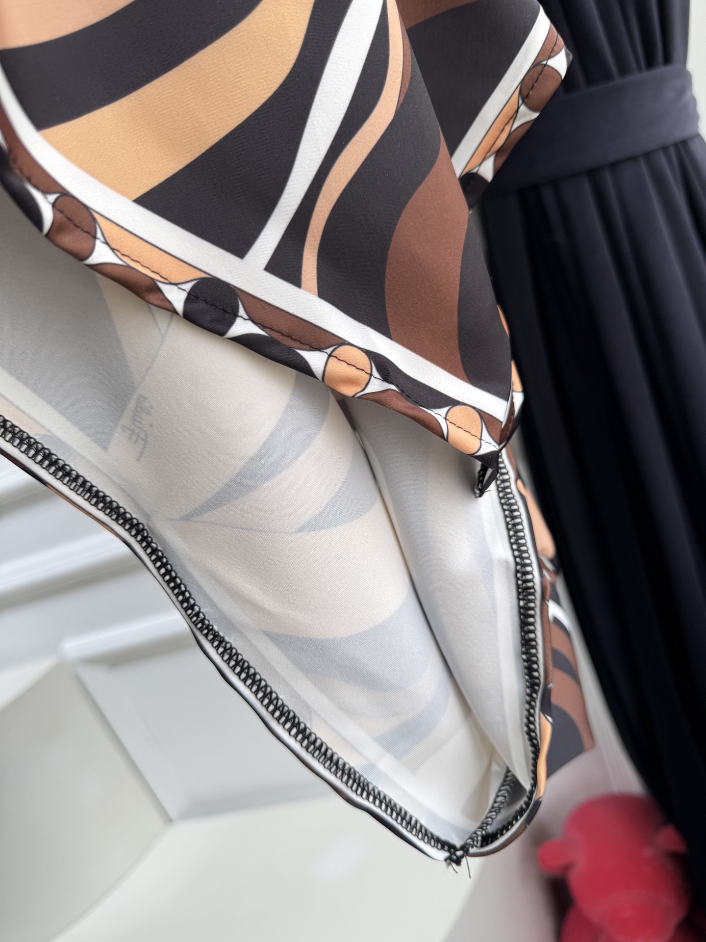 Pucci 印花挂脖真丝连衣裙通体覆盖 Marmo 漩涡印花，以黑、棕、米白、奶咖等大地色交织出流动的大