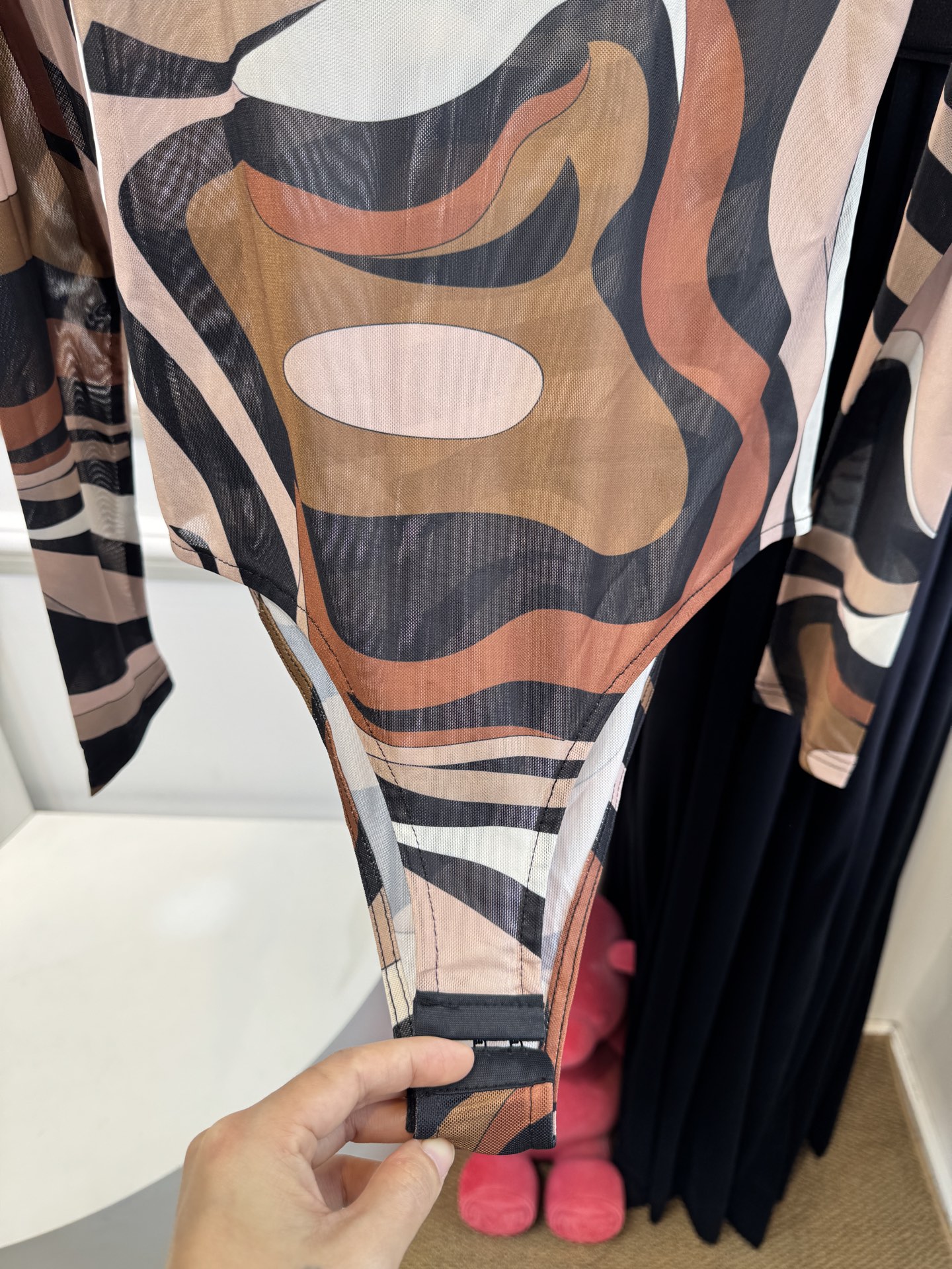 PUCCI 网纱连体衣图中采用的是品牌经典的 Marmo（大理石纹）/Iride 漩涡印花，也是Pucc