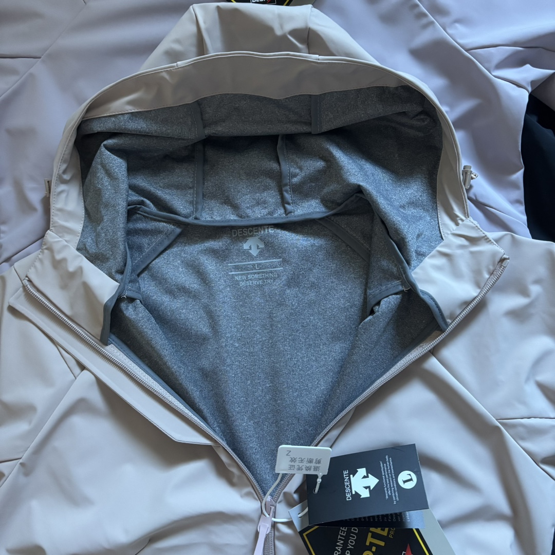 版本🐮货 上新💰295 高品质，雪梨纸精包装
DESCENTE迪桑特25秋季新品！女士全天候户外运动徒步爬山冲锋衣外套！掌柜力荐！太赞啦！线上线下同步！无论版型还是品质都没得挑了这款！全锦纶材质！手感灰常细腻柔顺！户外防风防水防污特性兼有！这不仅仅是惊喜！更多的是震撼了！日常通勤穿搭或户外徒步爬山都能轻松驾驭！轻松抵御各种恶劣天气！工艺细节做的都一丝不苟！手感党必入喜欢的千万别错过！

颜色：浅紫色 粉色 黑色
尺码：L-3XL（尺码表见图九）

