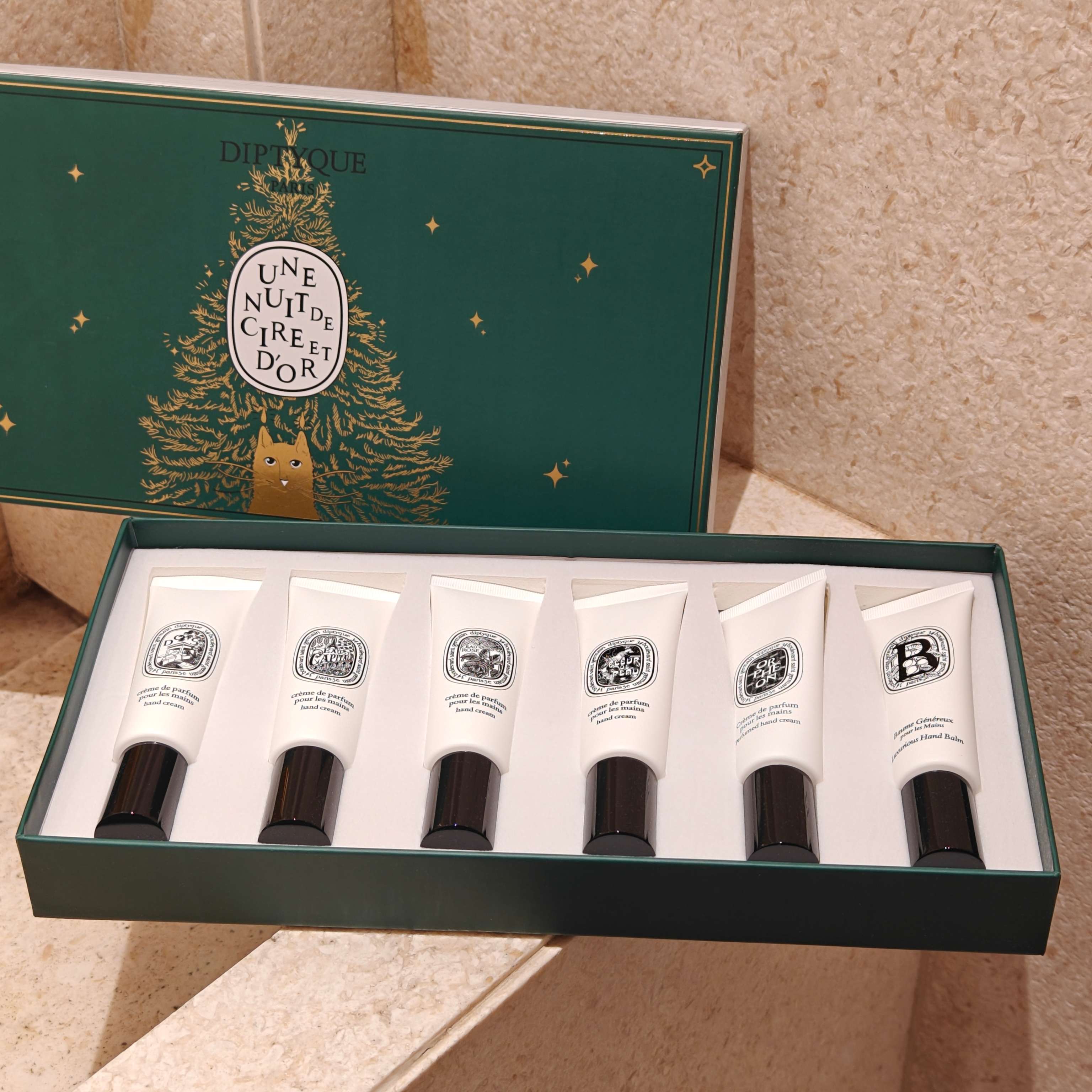 NO:939186,Tiptique 26 Edition Hand Cream Six-piece Set hides a whole universe of gentle fragrances in this limited hand care gift box with six 45ml hand creams. It brings together the six classic fragrances of Toussaint, Flower of Skin, Eau de Perrier, Eau de Rose, Almond Milk and Orfein, making every hand care a romantic olfactory journey.  The soft and silky cream texture gently covers dry fingertips, is delicate and easy to absorb, and has no sticky oily film feel. It slowly penetrates into the skin of hands, smoothes dryness and roughness in autumn and winter, repairs hangnails and dry lines, and protects fingertips to be soft and delicate.  Toussaint is hazy and lazy, rose water is lingering and fragrant, almond milk is warm and soft, each fragrance has its own style. When you raise your hand, the faint high-end fragrance lingers slowly, as if you are carrying a poetic garden with you.  The exquisite dark green holiday gift box has a gilt design that is full of atmosphere. Whether it is for personal use, the fragrance can be changed every day according to the mood; or it can be given to a close friend, it is a romantic gift full of heart. In daily life, let your hands be embraced by the fragrance and tenderness. Chaopin Department Store Hand Cream19860909蒂普提克26版护手霜六件套  把一整个温柔香氛宇宙,藏进这套限定护手礼盒六支45ml护手霜,汇集杜桑、肌肤之花、巴黎之水、玫瑰之水、杏仁牛奶、奥费恩六大经典香调,让每一次护手,都成为一场浪漫嗅觉漫游.  绵柔丝润的乳霜质地,温柔覆上干燥指尖,细腻好吸收,没有黏腻的油膜感.缓缓浸润双手肌肤,抚平秋冬的干涩粗糙,修护倒刺干纹,守护指尖柔软细腻.  杜桑朦胧慵懒,玫瑰之水缱绻芬芳,杏仁牛奶温润软糯,每一款香气都各有风情.抬手之间,淡淡的高级香调缓缓萦绕,仿佛随身携带着一座诗意花园.  精致墨绿色节日礼盒,鎏金设计氛围感十足.无论是自用,每日随心境更换香调；或是赠予挚友,都是满含心意的浪漫礼物.于细碎日常里,让双手被香气与温柔妥帖拥抱.,潮品百货护手霜,accessory