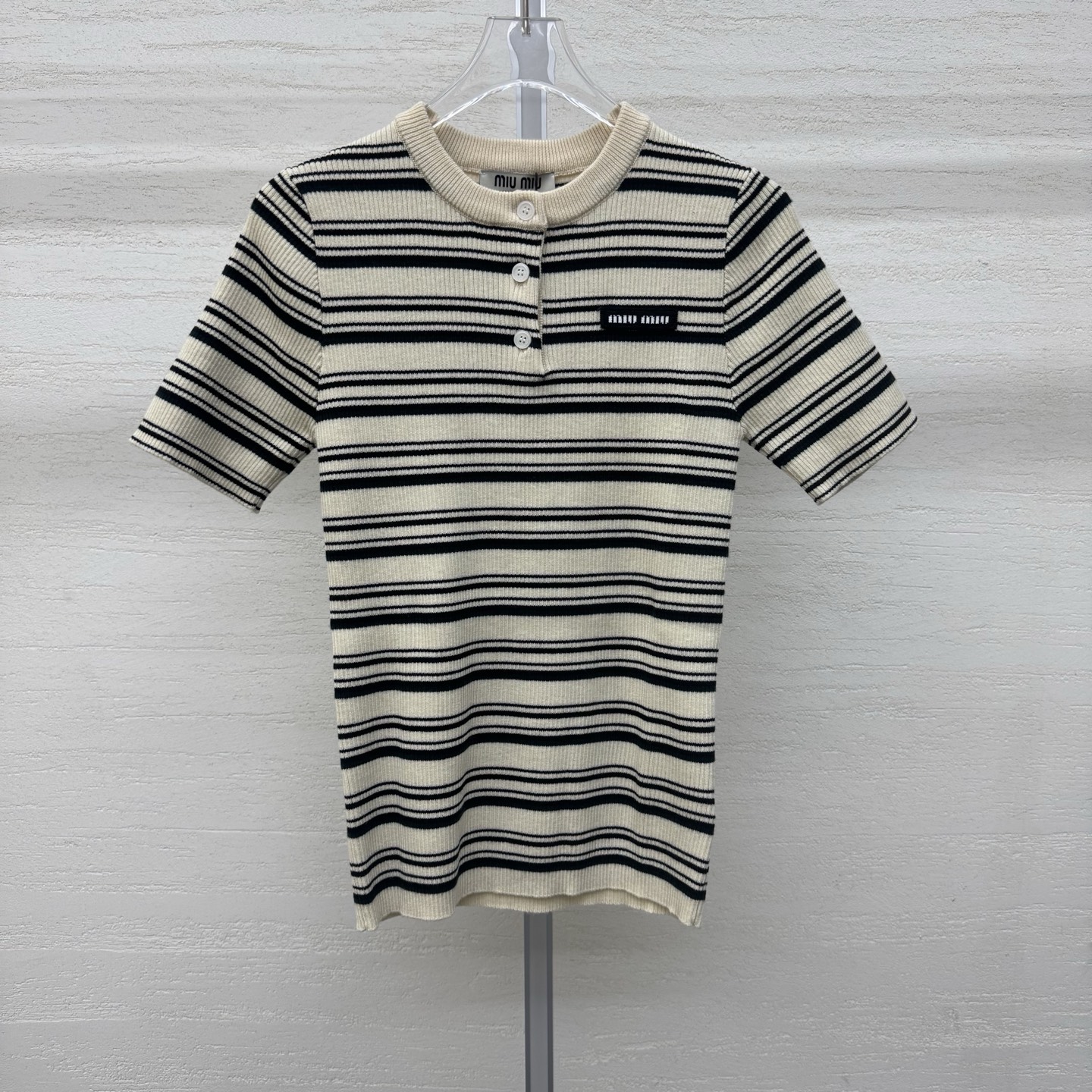 NO:752903,Support exchange MiuMi* 26SS early spring new slim-fitting striped short-sleeved top | Exclusively developed by yb!  High quality production!  The selected wool cashmere is skin-friendly, breathable and has a crisp texture. The slim tailoring outlines a neat figure, cleverly blending the girl's delicate and light luxury style. The contrasting stripes are retro and eye-catching, and the classic collar design is matched with metal buttons. The collar and stripe colors form a layered echo, showing exquisite details. The iconic brand logo on the left chest is a low-key identity and the finishing touch of the brand's genes. Ready-made S/M/L real shot details, miumiu, T-shirt,19860909支持换款MiuMi* 26SS早春新款 修身条纹短袖上衣丨独家yb开发！高版出品！精选羊毛羊绒亲肤透气且质感挺括,修身剪裁勾勒出利落身形,将少女的娇俏与轻奢格调巧妙融合.撞色条纹复古吸睛,经典回领设计搭配金属质感纽扣,领口与条纹色彩形成层次呼应,尽显精致细节.左胸处标志性的品牌徽标,低调彰显身份,是品牌基因的点睛之笔.现货发售S/M/L实拍细节图,,miumiu,T-shirt,,Women's clothing