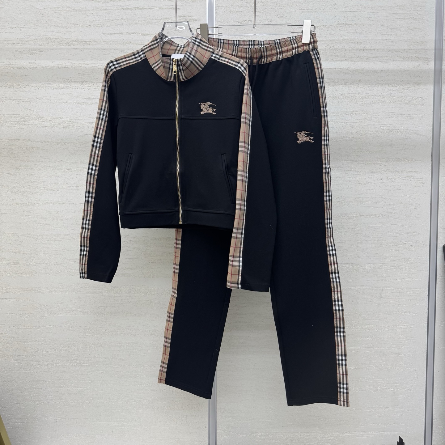 NO:752890,Support exchange Burb*rry 26Ss early spring new style equestrian knight micro-label plaid suit丨exclusively developed by yb!  Top quality production!  Made of high-count cotton fabric, it feels as soft and waxy as clouds, skin-friendly and comfortable, and is very practical to protect against wind and cold in early spring. The classic knight horse embroidered logo + spliced plaid pants echo the upper and lower parts of the suit perfectly. The body is embellished with the brand's iconic equestrian knight embroidered logo, and the thread embroidery outlines the brand recognition in a low-key manner.  , Simple yet detailed, the neat stand-up collar is matched with a full zipper opening and closing, and the loose oversize version is very tolerant to the body shape, easily creating a casual British casual accent. Ready-made S/M/L real shot details,, burberry, versace,19860909支持换款 Burb*rry 26Ss早春新款 马术骑士微标格纹套装丨独家yb开发！顶级高版出品！采用高支棉面料触感如云朵般软糯,亲肤又舒适,早春防风御寒超实用.经典的骑士马绣标+拼接格纹裤子上下呼应完美成套.衣身点缀品牌标志性的马术骑士刺绣徽标,线绣纹在低调中勾勒出品牌辨识度,简约却不失细节感,利落的立领搭配全拉链开合,宽松的oversize版型对身形都超包容,轻松打造随性的英伦休闲腔调.现货发售S/M/L实拍细节图,,burberry,versace,,Women's clothing