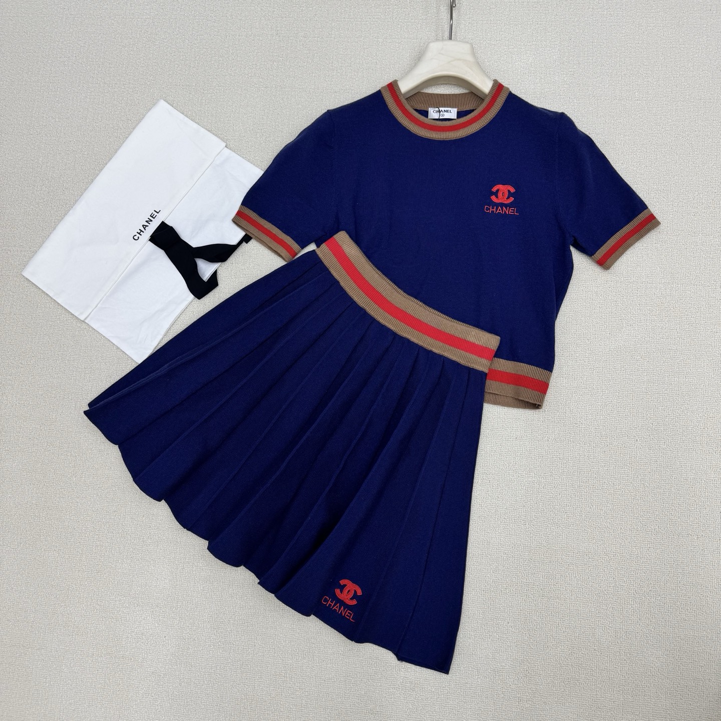 NO:803670,chan*26Ss new spring and summer style thread contrasting edge knitted short-sleeved + pleated skirt suit丨exclusively developed by yb!  Top quality production!  Virgin wool knitted fabric, comfortable and breathable. Contrast color knitted short round neck and short sleeves with threaded collar and cuffs, + high waist pleated skirt with contrasting letters. Lettering embroidery on the chest and hem matches the upper and lower parts. It has a low-key yet noble temperament. The upper and lower color-blocked threads not only add a sweet and cool design layer, but also highlight the brand atmosphere.  The pleated skirt uses neat pleats to outline girlish lines, and the short version raises the waistline, forming a perfect golden ratio with the short top, easily creating a playful and slim figure. Two colors are available for sale in stock S/M/L real shot details, chanel, skirts, T-shirt, gold,19860909chan*26Ss春夏新款 螺纹撞色边针织短袖+百褶半裙套装丨独家yb开发！顶级高版出品！初剪羊毛针织面料 舒适又透气 领口袖口螺纹撞色针织短款圆领短袖,+高腰撞色字母百褶半裙 胸前与下摆字母刺绣上下乎应 自带低调又不失高贵的气质 上下拼色螺纹既增添了甜酷的设计层次 又突显品牌气息 百褶半裙则以利落的褶裥勾勒出少女感线条,短款版型拉高腰线,与短款上衣形成完美的黄金比例,轻松打造俏皮又显瘦的身形.两色 现货发售S/M/L实拍细节图,,chanel,skirts,T-shirt,gold,,Women's clothing