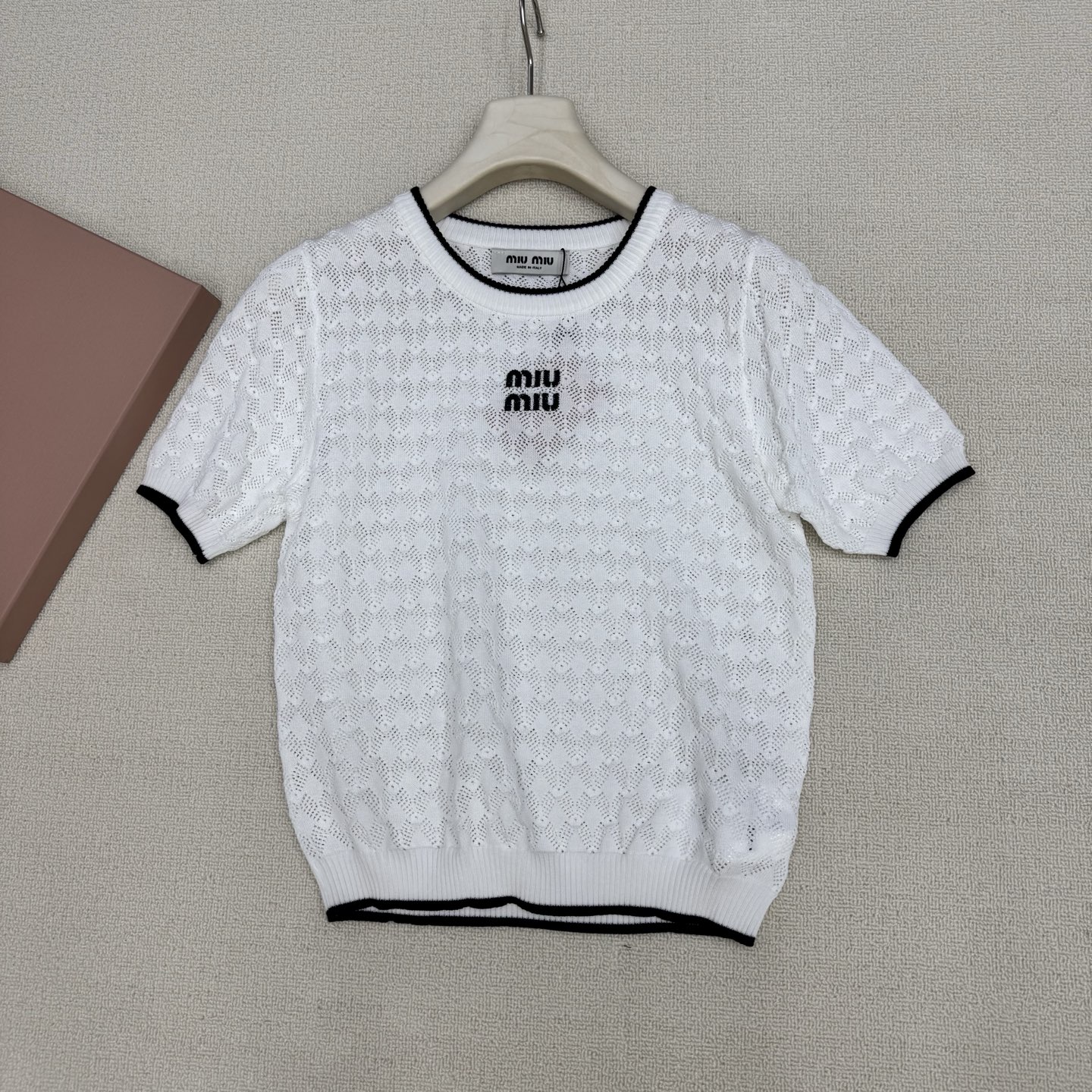 NO:807840,miumi*26 new style knitted round neck short-sleeved hollow rhombus with breathable texture. Black and white contrast edging. Refreshing and exquisite. Letter embroidery on the chest. Low-key style. Versatile for daily use. Not picky. Ready for sale in size 363840. Real shot details,,miumiu,T-shirt,19860909miumi*26新款针织圆领短袖镂空菱格 自带透气肌理感 黑白撞色包边 清爽又显精致 胸前字母刺绣 低调点明风格 日常百搭不挑人 现货发售尺码363840实拍细节图,,miumiu,T-shirt,,Women's clothing
