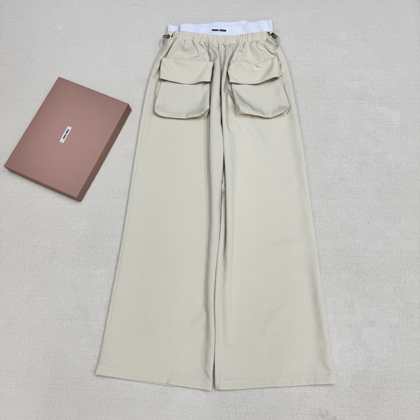 NO:807856,miumi*26Ss new spring and summer style contrasting letter threaded waist patchwork overalls丨Exclusive high-end version!  The iconic white-edged contrasting waistband brightens up the whole, and the two-tone navy blue and light khaki colors suit a variety of spring styles. Made of crisp and drapey cotton blended fabric, the front panel is independently cut and spliced with large pockets to design a cool workwear style with loose wide legs and a lazy and relaxed feel. The three-dimensional pleat design on the trousers enhances the functional attributes of the workwear, and the drawstring waistband is comfortable.  Style and style. It can be paired with a short waistless top to create an American hot girl style, or layered with a loose sweatshirt to create a casual street feel. It is a core item in the summer wardrobe that is both recognizable and practical. Two colors are available in stock, S/M/L, real shot details,, miumiu, hoodie, sweatshirts,19860909miumi*26Ss春夏新款 撞色字母螺纹腰拼接工装裤丨独家高版出品！以标志性的白边撞色腰头点亮整体,藏蓝色与浅卡其双色调适配多元春日风格.采用挺括垂坠的棉质混纺面料,前片独立剪栽拼接大口袋设计工装酷酷宽松阔腿自带慵懒松弛感,裤身立体褶裥设计强化工装机能属性,抽绳腰头兼顾舒适度与造型感.可搭配短款露腰上衣打造美式辣妹风,或叠穿宽松卫衣营造随性街头感,是夏季衣橱里兼具辨识度与实穿性的核心单品.两色现货发售S/M/L实拍细节图,,miumiu,hoodie,sweatshirts,,Women's clothing