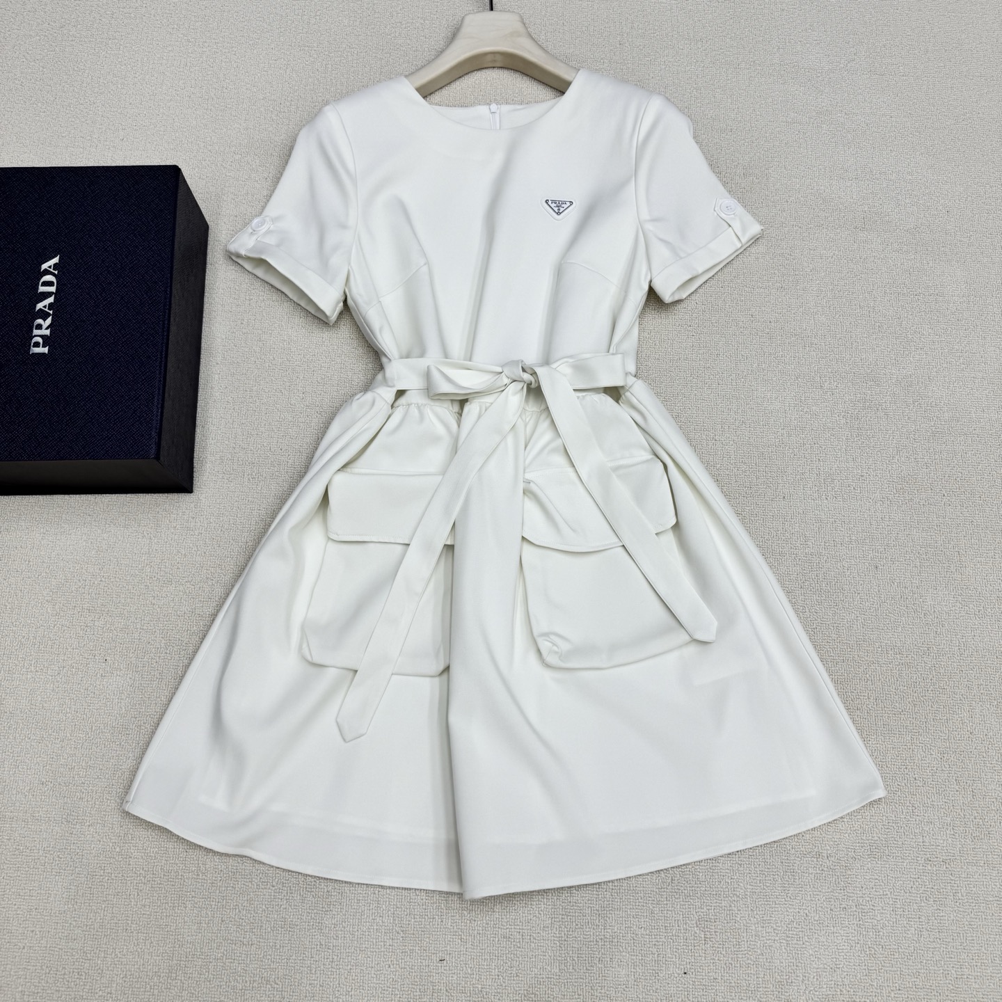 NO:807841,Prad* 26Ss spring and summer new style belted work dress丨exclusively developed by yb!  Top quality production!  Silk cotton fabric is comfortable and skin-friendly  The upper body feels soft and has a vertical texture. The classic triangular logo brand badge is low-key and cool, and it has a workwear-style cut with round neck + turned sleeves + large pockets. The extended zipper opening and closing design of the back panel takes into account the convenience of putting on and taking off and the change of shape. The stiletto waist design can freely tighten the waistline.  It outlines a neat X-shaped silhouette, weakens the lazy feeling of the loose version, and highlights the body proportions. It is a wardrobe finishing touch that combines design, practicality and individual style concepts. Two colors are available in stock, S/M/L, real shot details, prada, skirts,19860909Prad* 26Ss春夏新款 束腰挷带工装连衣裙丨独家yb开发！顶级高版出品！丝质棉面料舒服亲肤 手感软糯上身自带垂直质感,经典三角标品牌胸章低调且不失贵气千金的酷酷感,圆领+翻袖+大口袋的工装风剪裁,后片加长拉链开合设计兼顾穿脱便利与造型变化,挷带腰设计能自由收束腰线,勾勒出利落的X型廓形,弱化宽松版型的慵懒感,凸显身形比例.是一件兼具设计感、实穿性与个性风格理念的衣橱点睛之选.两色现货发售S/M/L实拍细节图,,prada,skirts,,Women's clothing