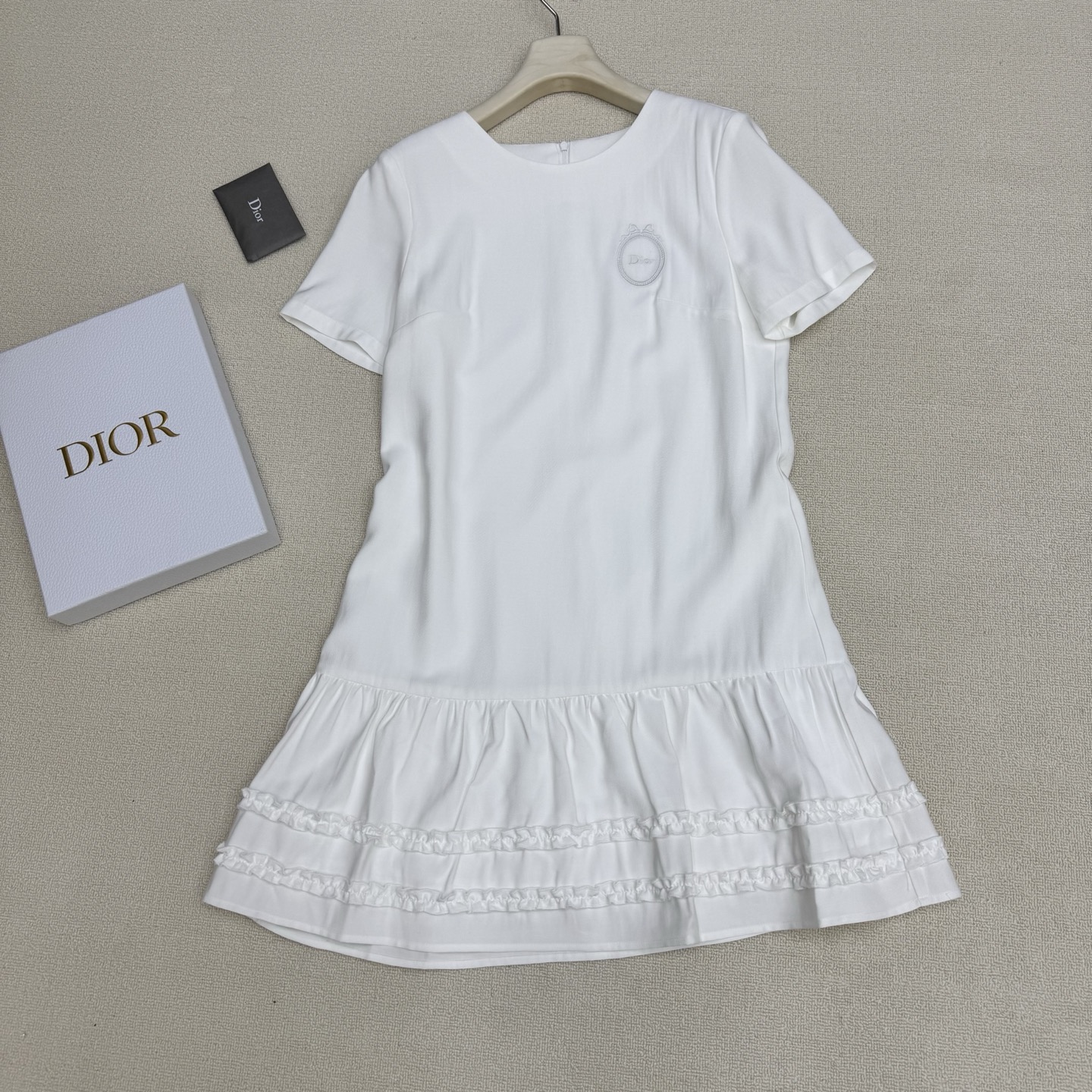 NO:807853,Dio* 26Ss spring and summer new style round neck dress with badge letter embroidery丨Exclusively developed by yb!  Top quality production!  It interprets the romantic texture of French girls with soft and solid colors. The fine silk cotton material is skin-friendly and breathable. The classic round neck version is suitable for various scenes. The garland embroidery on the left chest is the finishing touch of the brand. The loose tailoring combines comfort and style. The extended zipper is provided at the back.  Designed to be easy to put on and take off, creating a casual daily life, the spliced hem wood ear lace design combination interprets the sweet and cool style. It is a gentle and textured item in the early spring wardrobe. Two colors are available in stock, S/M/L, real shot details, dior, skirts,19860909Dio* 26Ss春夏新款 胸章字母刺绣圆领连衣裙丨独家yb开发！顶级高版出品！以柔和纯色系诠释法式少女的浪漫质感.细腻丝质棉料亲肤透气,经典圆领版型适配多元场景,左胸处的花环刺绣为品牌点睛之笔,宽松剪裁兼具舒适度与造型感,后加长拉链设计穿脱轻松方便,打造随性日常,拼接下摆木耳朵花边设计组合诠释甜酷风格,是早春衣橱里的温柔质感单品.两色现货发售S/M/L实拍细节图,,dior,skirts,,Women's clothing