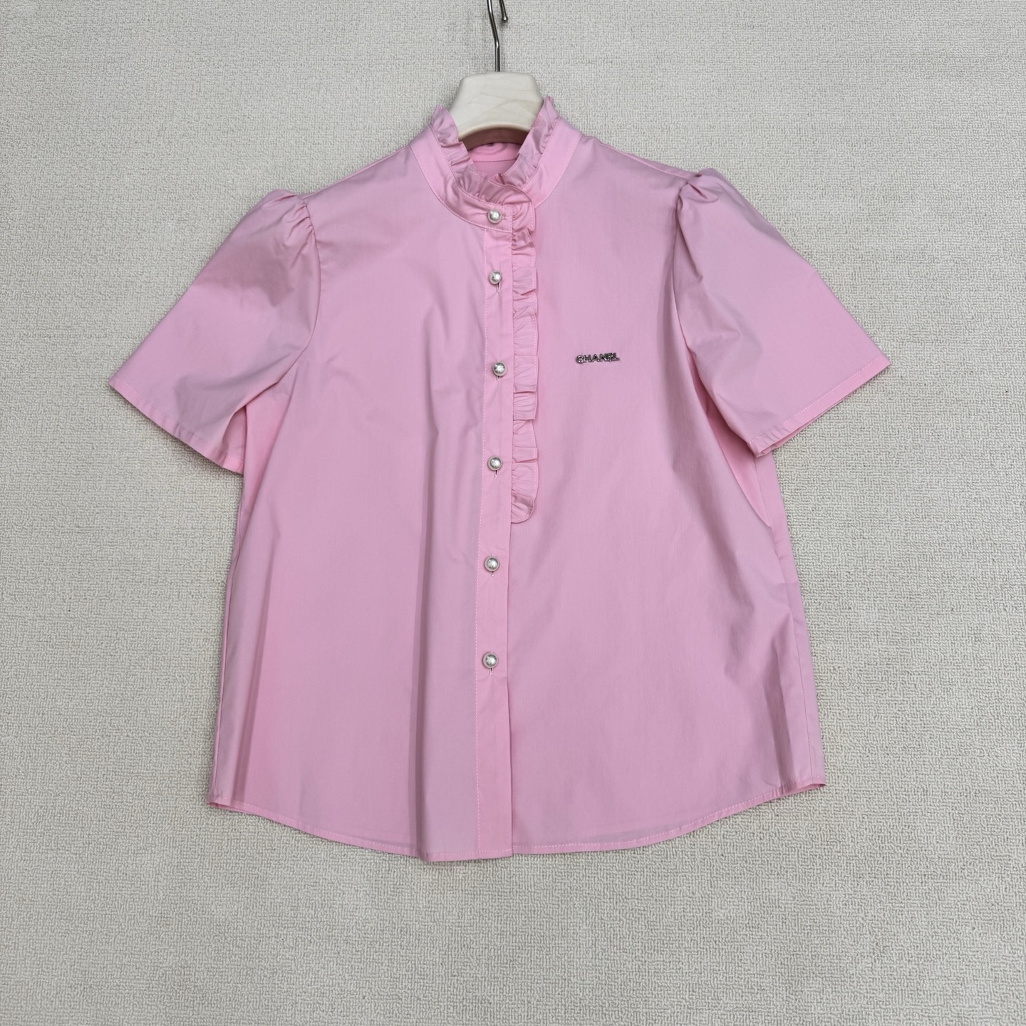NO:807861,chan**26Ss new spring and summer fungus college style short-sleeved shirt丨exclusively developed by yb!  Top quality production!  The custom-made molded hardware letter badge is the finishing touch of the brand. The solid white and pink gentle lace outlines a sweet college feel. The high-count cotton fabric is breathable and skin-friendly. The crisp version hides small fat. The chest Logo hardware logo + double C engraved pearl breast buttons.  Low-key declaration of noble status, whether it is a sweet girl style with a pleated skirt, or a light and mature look with a suit, it can be easily controlled. This shirt is the most understanding girl's heart in spring. Two colors are available in stock, S/M/L real shot details, chanel, skirts, shirts, T-shirt, business suit,19860909chan**26Ss春夏新款木耳边学院风短袖衬衫丨独家yb开发！顶级高版出品！订制开模五金字母胸章为品牌的点睛之笔,纯色系白色粉色温柔花边勾勒出甜美学院感,高支棉面料透气亲肤,挺括版型藏住小赘肉,胸口Logo五金标识+双C刻字珍珠排扣 低调宣告贵气身份,无论是配百褶裙的甜妹风,还是搭西装的轻熟感,都能轻松驾驭.这件衬衫,是春天里最懂少女心的存在.两色现货发售S/M/L实拍细节图,,chanel,skirts,shirts,T-shirt,business suit,,Women's clothing