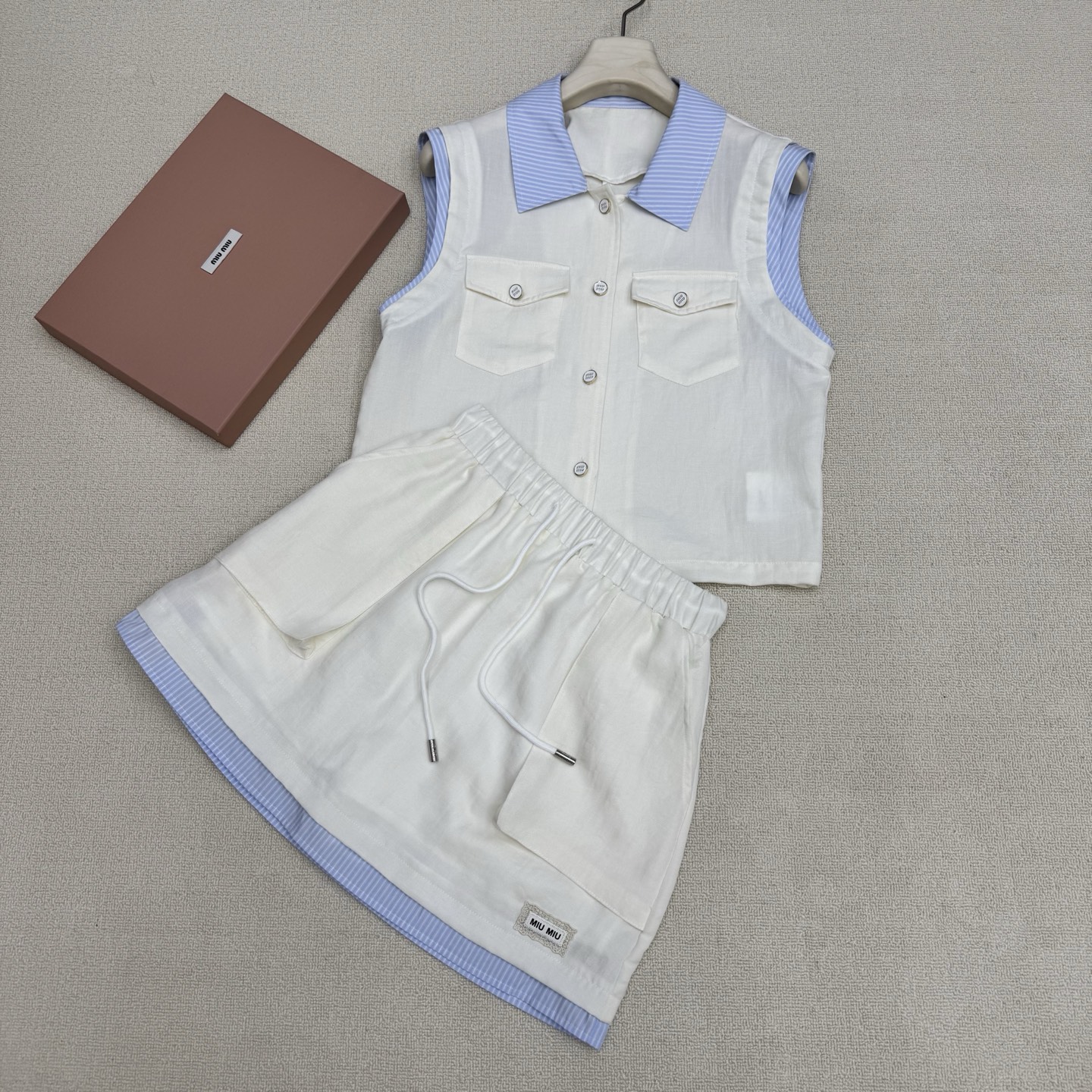 NO:808392,miumi*26Ss new spring and summer polo collar sleeveless shirt + drawstring work skirt set丨Exclusive high-end version!  Minimalist and relaxed workwear-style suit, casual healing suit, shirt spliced with contrasting collar design + elastic waist skirt hem with contrasting splicing upper and lower to match. It is a very suitable suit for summer. Breathable silk and cotton blend material. The hem brand micro-label is a poke point + patch workwear large pocket. Wearing it casually exudes a bit of 'artistic elegance' and just reveals the original 'slow' attribute.  ,Two colors ready for sale S/M/L real shot details,,miumiu,skirts,shirts,19860909miumi*26Ss春夏新款 polo领无袖衬衫+抽绳工装半裙套装丨独家高版出品！极简松弛感拉满工装风套装 随性治愈系套装 衬衫拼接撞色领设计+松紧腰半裙下摆撞色拼接上下成套相呼应.夏天穿很合适的套装 自带呼吸感的丝质棉伦混纺材质 下摆品牌微标为戳点+贴片工装大口袋 随便一套一穿就散发着几分“文艺贵” 恰到好处的透露着原生的“慢”属性 ,两色现货发售S/M/L实拍细节图,,miumiu,skirts,shirts,,Women's clothing