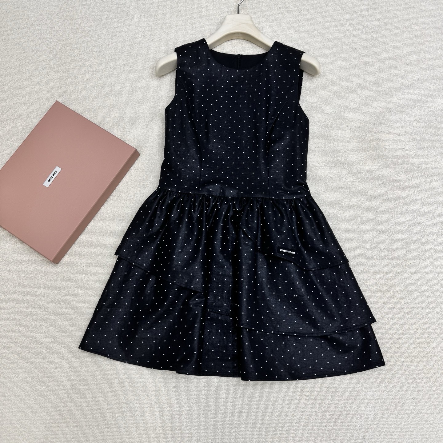 NO:823017,miumi*26 new spring and summer French retro polka dot round neck sleeveless dress. The small skirt has its own elegant filter. The classic starry polka dots are paired with matte black and milky white background, which brings out the French romance and girlishness. The exquisite three-layer cake skirt gently reduces age, and the small micro logo on the skirt embellishes the brand atmosphere. The A-line skirt with waist can easily outline the body curve, and the waist can be slimmed down and the legs can be lengthened instantly.  It is full of details and can be worn on dates, commuting, and light gatherings. It can be worn alone or paired with suits and cardigans to create different styles. Two colors, ready for sale, smL real shot details,, miumiu, skirts, business suit,19860909miumi*26春夏新品法式复古波点圆领无袖连衣裙 自带优雅滤镜的小裙籽,经典满天星波点搭配亚光黑和奶白底色,把法式浪漫与少女感拉满.精致三层蛋糕裙摆温柔减龄,裙摆小微标点缀品牌气息,收腰A字裙摆轻松勾勒身材曲线,秒变腰细腿长. 细节感直接拉满,约会、通勤、轻聚会都能hold住,可单穿也可搭配西装、开衫打造不同风格.两色,现货发售smL实拍细节图,,miumiu,skirts,business suit,,Women's clothing