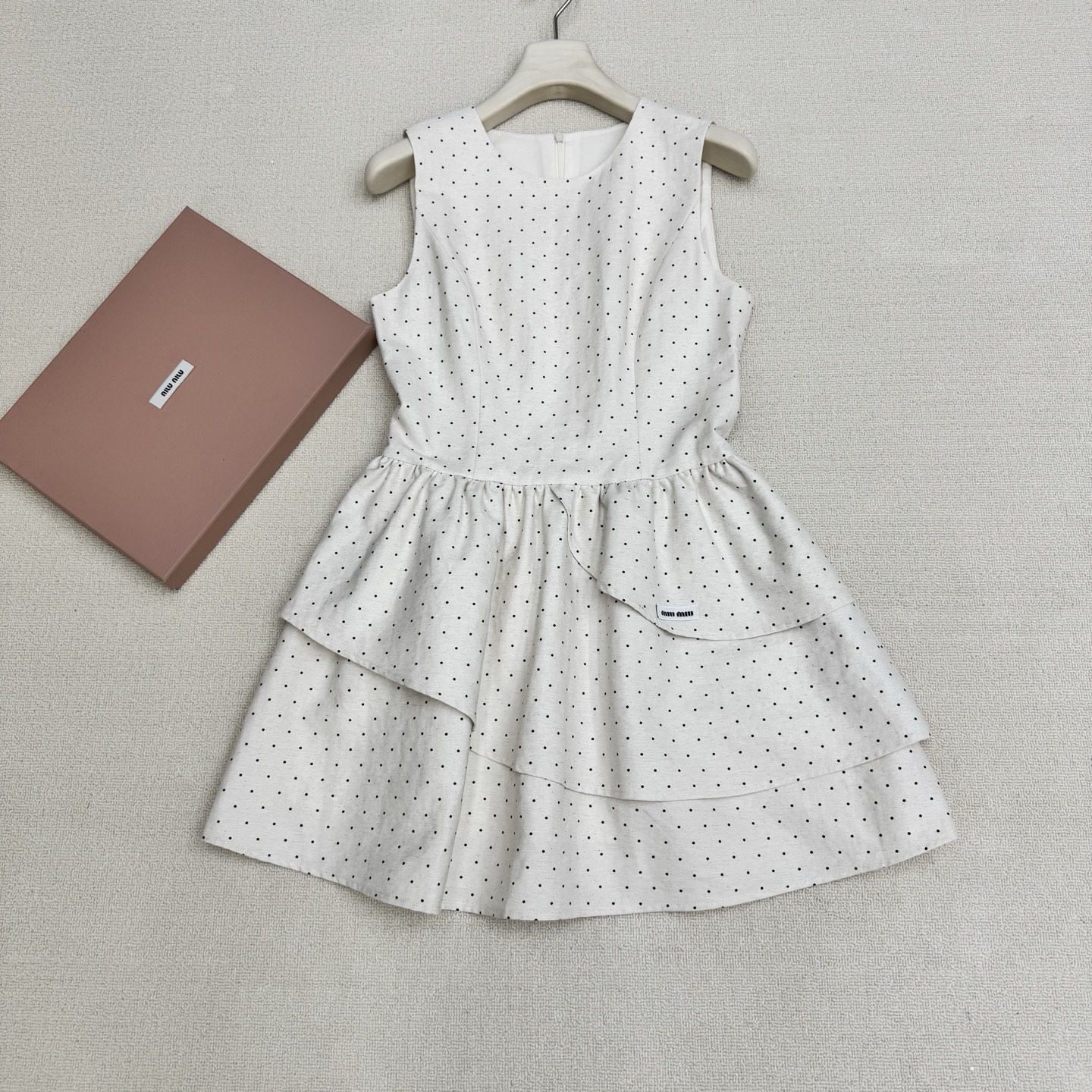 NO:823007,miumi*26 new spring and summer French retro polka dot round neck sleeveless dress. The small skirt has its own elegant filter. The classic starry polka dots are paired with matte black and milky white background, which brings out the French romance and girlishness. The exquisite three-layer cake skirt gently reduces age, and the small micro logo on the skirt embellishes the brand atmosphere. The A-line skirt with waist can easily outline the body curve, and the waist can be slimmed down and the legs can be lengthened instantly.  It is full of details and can be worn on dates, commuting, and light gatherings. It can be worn alone or paired with suits and cardigans to create different styles. Two colors, ready for sale, smL real shot details,, miumiu, skirts, business suit,19860909miumi*26春夏新品法式复古波点圆领无袖连衣裙 自带优雅滤镜的小裙籽,经典满天星波点搭配亚光黑和奶白底色,把法式浪漫与少女感拉满.精致三层蛋糕裙摆温柔减龄,裙摆小微标点缀品牌气息,收腰A字裙摆轻松勾勒身材曲线,秒变腰细腿长. 细节感直接拉满,约会、通勤、轻聚会都能hold住,可单穿也可搭配西装、开衫打造不同风格.两色,现货发售smL实拍细节图,,miumiu,skirts,business suit,,Women's clothing