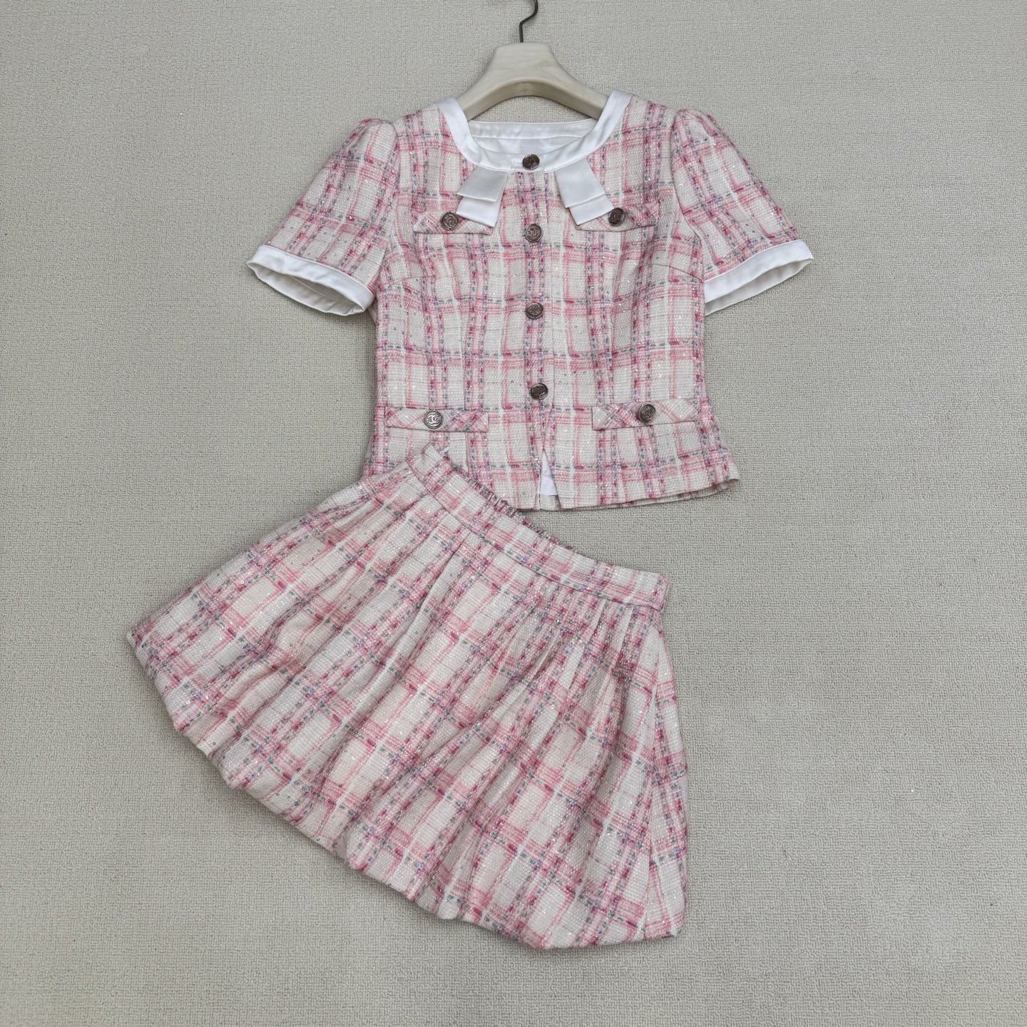 NO:822975,Chane* 26Fw new spring and summer round neck sequined plaid tweed short jacket flower bud skirt suit丨exclusively developed by yb!  Top quality production!  This plaid sequined tweed suit is a must-have for this season's elegance. The light pink mixed-color plaid tweed all-over sequined fabric is made of multi-color yarns interwoven. With the support of sequins all over the body, it reflects colorful luster under the light, giving it a noble and gorgeous texture; the short jacket uses a contrasting collar  The knotted round neck design, neat lines modify the proportion of the neck, double C single-row buttons are embellished, and exquisite details are hidden in the simplicity. The flower bud skirt of the same series cleverly modifies the leg lines with a fluffy version, echoing the short cut of the jacket, creating a golden ratio of 30 to 70 points. Available now.  S/M/L real shot details,,chanel,skirts,jackets & coats,gold,19860909Chane* 26Fw春夏新款 圆领亮片格子粗花呢短款外套花苞半裙套装丨独家yb开发！顶级高版出品！这套格子亮片粗花套装是本季必入的优雅担当.浅粉色混彩格子粗花呢满幅亮片面料由多色纱线交织而成,通体亮片的加持下在光线下折射出多彩光泽,自带贵族华丽质感；短款外套采用撞色领结圆领设计,利落线条修饰颈部比例,双c单排纽扣点缀其间,简约中暗藏精致细节.同系列花苞半裙以蓬松感版型巧妙修饰腿部线条,与外套的短款剪裁相呼应,打造三七分黄金比例.现货发售 S/M/L实拍细节图,,chanel,skirts,jackets & coats,gold,,Women's clothing