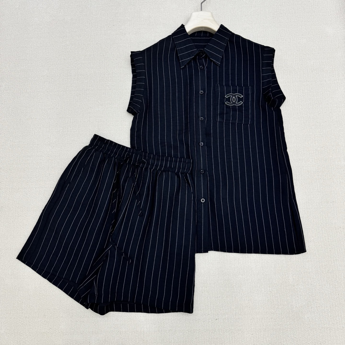 NO:827894,chan*26Ss new spring and summer style vertical striped sleeveless shirt + high-waisted drawstring shorts set | Exclusive high-end version!  A striped suit with a relaxed feel. Casual healing suit. The double C brand embroidery on the shirt pocket is the punch point + the elastic waist and high waist shorts pockets have double C embroidery on the upper and lower sides. It is a very suitable suit for summer. The custom-made high-branch cotton blend material has a breathable feeling. It exudes a bit of 'artistic nobility' when worn casually. It just reveals the original 'slow' attribute.  ,两色现货发售S/M/L实拍细节图,,chanel,shorts,shirts,19860909chan*26Ss春夏新款 竖条纹无袖衬衫+高腰抽绳短裤套装丨独家高版出品！松弛感拉满的条纹套装 随性治愈系套装 衬衫口袋双C品牌刺绣为戳点 +松紧腰高腰短裤口袋字母双C上下刺绣成套相呼应.夏天穿很合适的套装 自带呼吸感的订制高枝棉伦混纺材质 随便一套一穿就散发着几分“文艺贵” 恰到好处的透露着原生的“慢”属性 ,两色现货发售S/M/L实拍细节图,,chanel,shorts,shirts,,Women's clothing