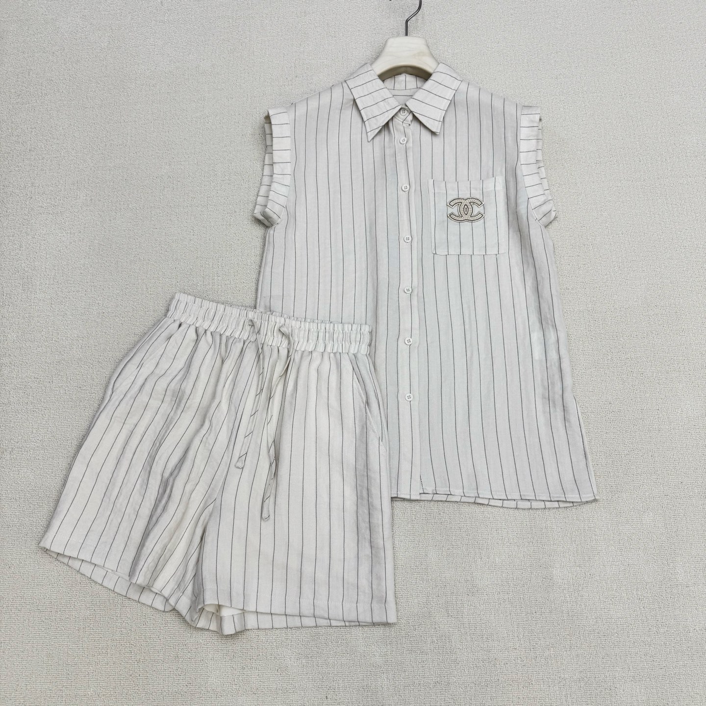 NO:827874,chan*26Ss new spring and summer style vertical striped sleeveless shirt + high-waisted drawstring shorts set | Exclusive high-end version!  A striped suit with a relaxed feel. Casual healing suit. The double C brand embroidery on the shirt pocket is the punch point + the elastic waist and high waist shorts pockets have double C embroidery on the upper and lower sides. It is a very suitable suit for summer. The custom-made high-branch cotton blend material has a breathable feeling. It exudes a bit of 'artistic nobility' when worn casually. It just reveals the original 'slow' attribute.  ,Two colors ready for sale S/M/L real shot details,,chanel,shorts,shirts,19860909chan*26Ss春夏新款 竖条纹无袖衬衫+高腰抽绳短裤套装丨独家高版出品！松弛感拉满的条纹套装 随性治愈系套装 衬衫口袋双C品牌刺绣为戳点 +松紧腰高腰短裤口袋字母双C上下刺绣成套相呼应.夏天穿很合适的套装 自带呼吸感的订制高枝棉伦混纺材质 随便一套一穿就散发着几分“文艺贵” 恰到好处的透露着原生的“慢”属性 ,两色现货发售S/M/L实拍细节图,,chanel,shorts,shirts,,Women's clothing