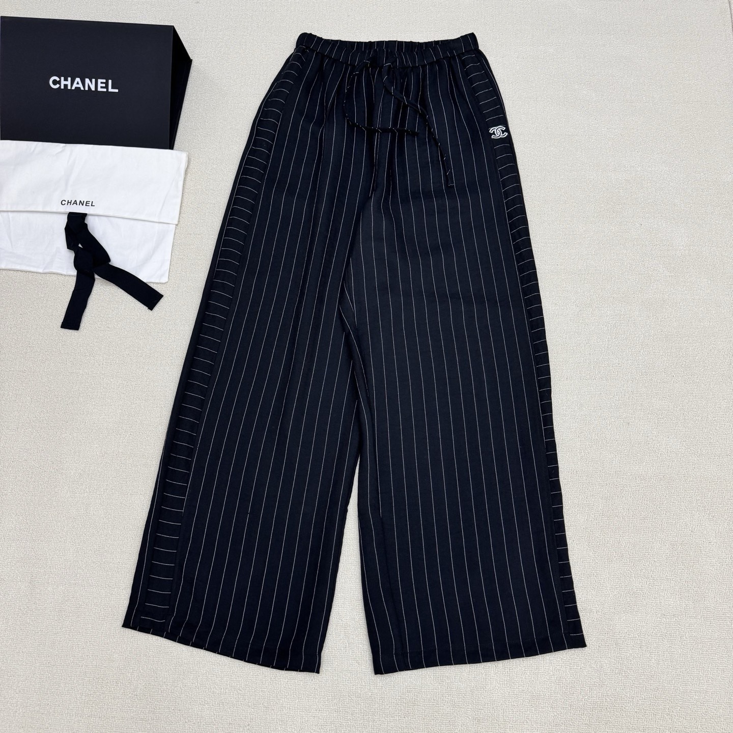 NO:833719,Chan*2026SS new spring and summer series // Retro vertical striped wide-leg pants. The vertical stripes have a sense of vertical extension, which can visually lengthen the leg lines. The high-waist drawstring design. The double-C embroidery on the pockets and the horizontal stripes on the trouser legs and vertical stripes design enhance the visual impact and the overall sense of sophistication. It is a visual heightening tool that makes you wear a lazy and relaxed body. Available now in two colors SML,,chanel,19860909Chan*2026SS春夏上新系列//复古竖条纹阔腿裤竖条纹自带纵向延伸感,视觉上能拉长腿部线条,高腰抽绳设计.口袋双C刺绣侧边横纹裤腿竖纹设计,提升了视觉冲激整体精致感, 视觉显高神器,把慵懒松弛穿在身上.现货发售两色 SML,,chanel,,Women's clothing
